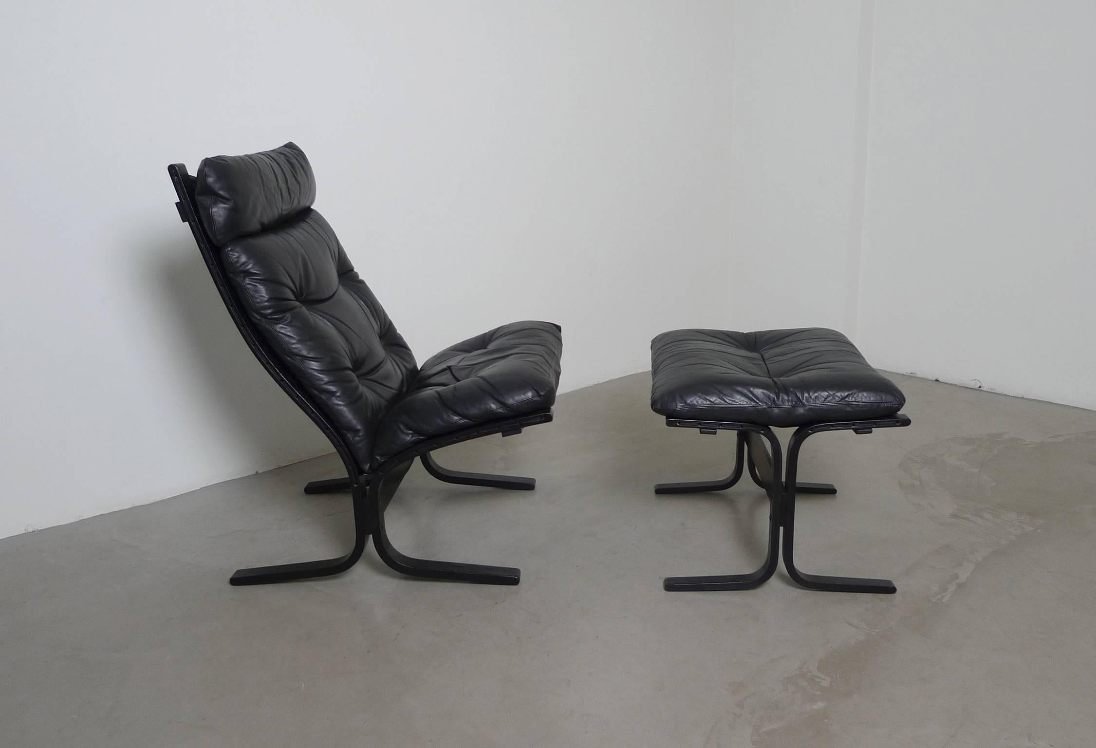 The Siesta lounge chair was designed by Ingmar Relling in the 1960s for the Norwegian manufacturer Westnofa. High back chair and ottoman have black leather covers and both frames are made of black bated laminated wood. The condition is very good.