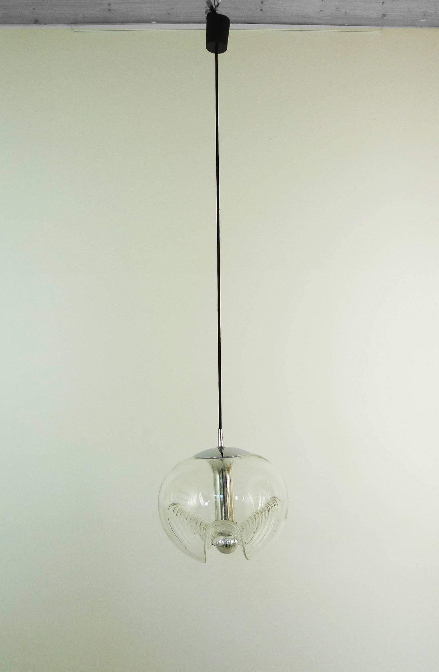 This pendant was designed by Koch and Lowy for the German manufacturer Peill & Putzler in the 1970s. It's thick clear glass body is significantly waved for an interesting light spreading.
The ceiling lamp has an E 27 socket and it is wired for