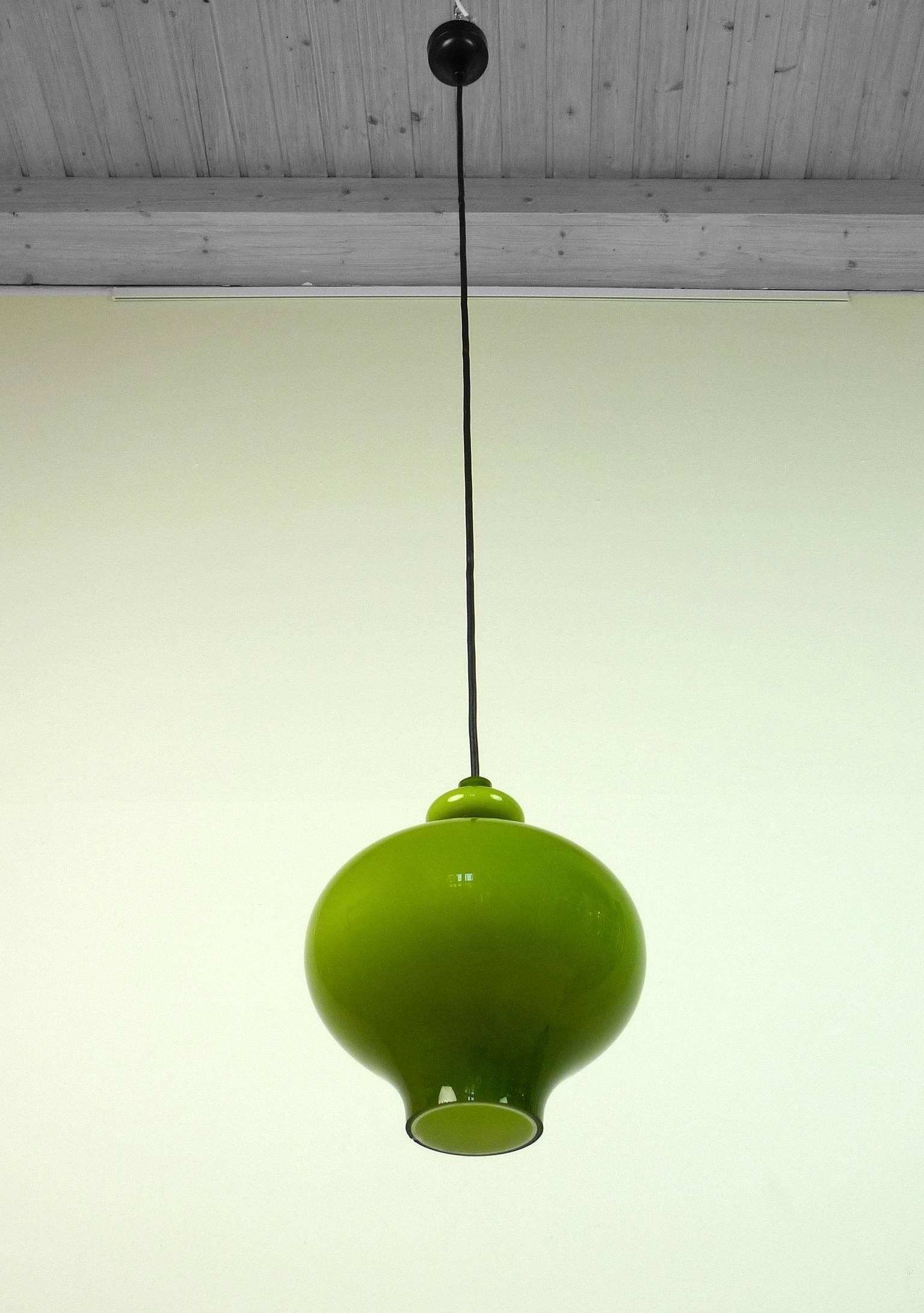 The green onion body of the pendant lamp is made of handblown glass from Holmegaard and has one E 27 bulb holder inside. The lamp was produced by the German manufacturer Staff Leuchten in the 1960s and is wired for German standard. The pendant is in