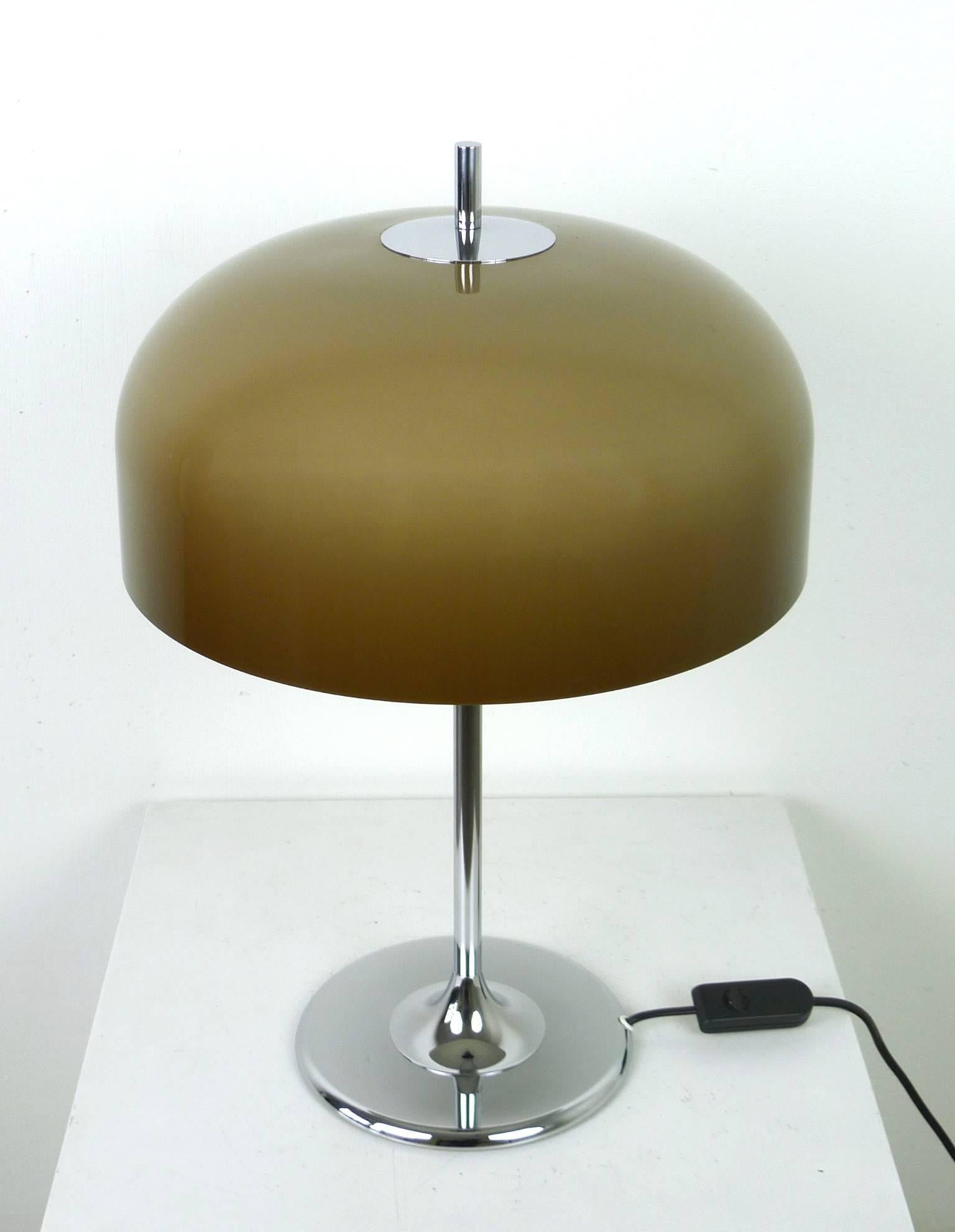 This table lamp has a chromed tulip base and a plastic shade from the 1970s. It has two E 27 bulb holders and is in very good original condition.