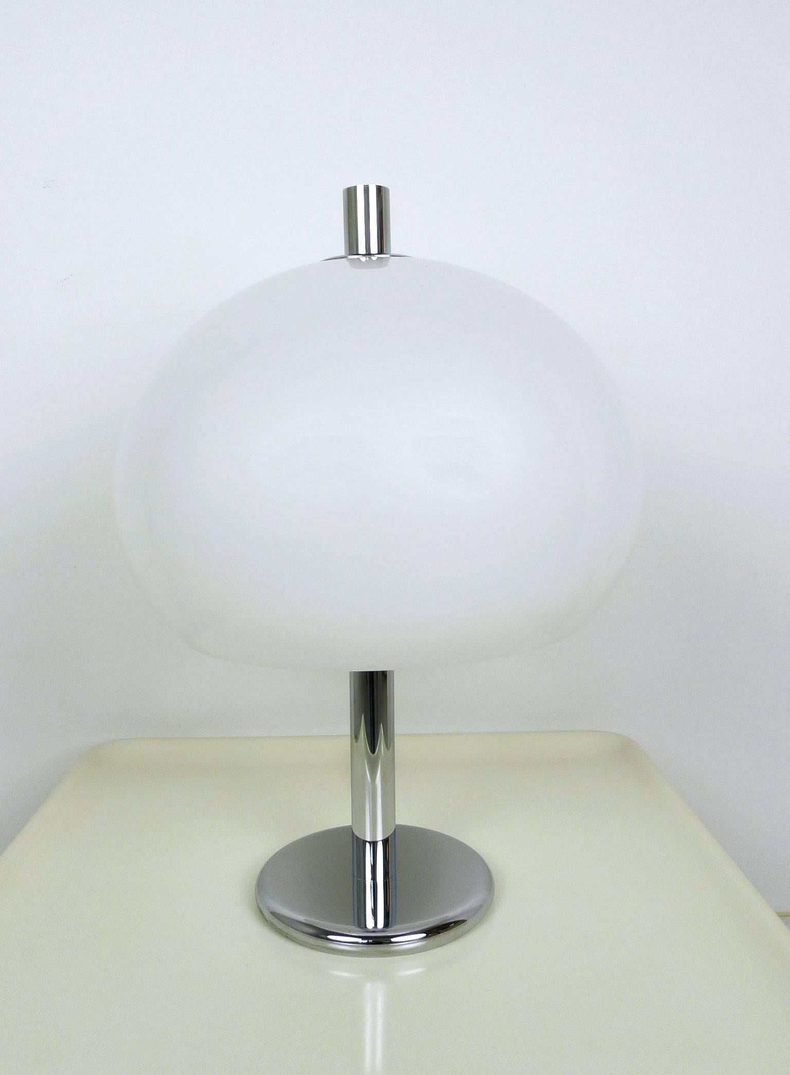Large 1970s table lamp from Germany. It features a white plastic shade with two E 27 bulb sockets inside and a round chromed base. The lamp is in very good original condition.