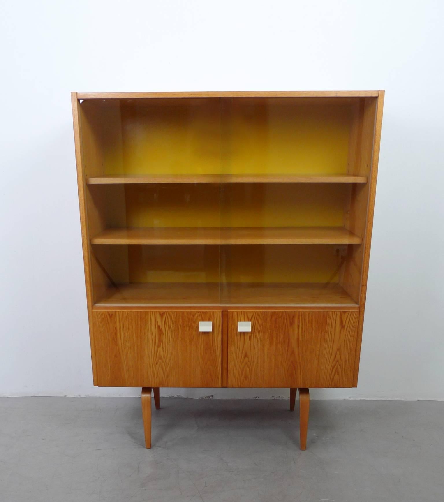 1960s display cabinet with two glass sliding doors and two folding doors from Deutsche Werkstätten Hellerau. This bookcase is part of the Möbelserie 427 designed by Franz Ehrlich in 1964.
The bookcase is in very good original condition, only the