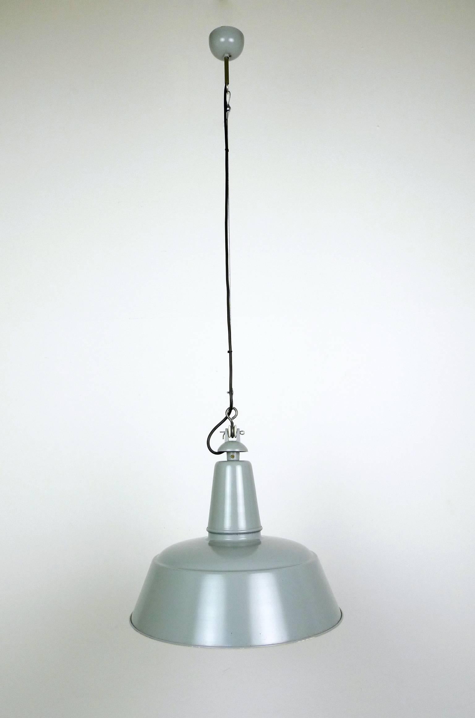 This Industrial pendant from the 1950s features a light-gray lacquered shade with a white inside. The shade measures 40 cm without cable and the lamp features an E 27 ceramic socket. The electric wire is renewed. Shade and ceiling fixture are in