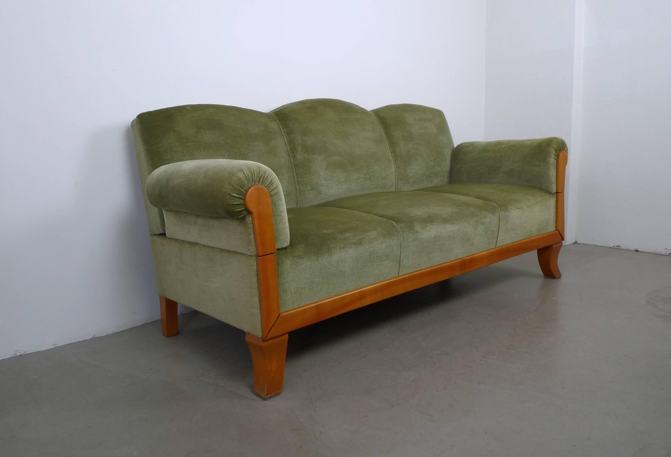 Functional three-seat sofa with a cherry frame from Germany. It is upholstered in green velour fabric and is padded with a spring-cage. Both armrests can be locked into three different positions on the brackets or completely removed for sleeping.