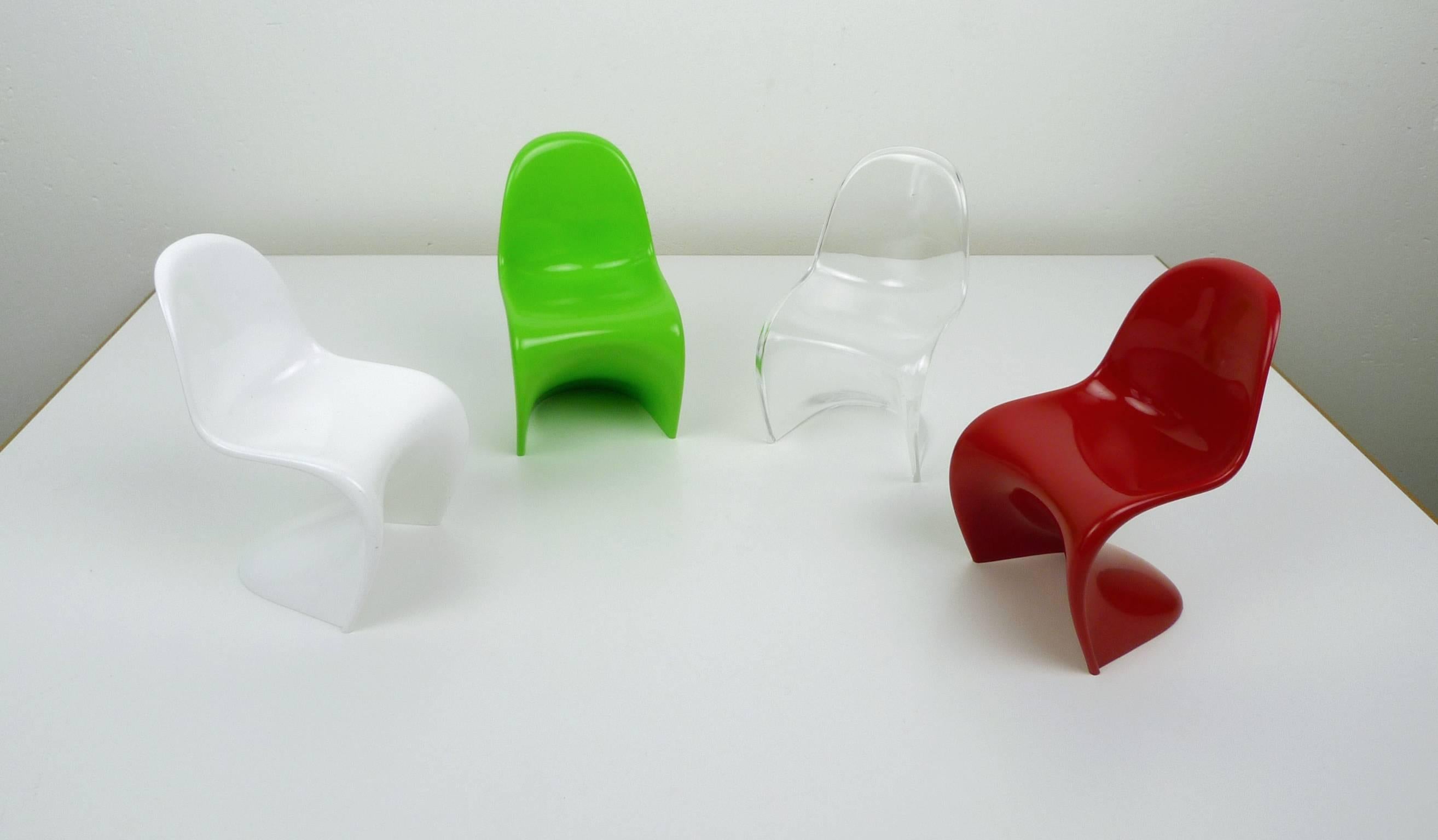 Four miniatures of the Verner Panton chair made of white, green, transparent and red plastics from the 1970s. The scale is 1:6. 
They are stackable and in a very good shape.