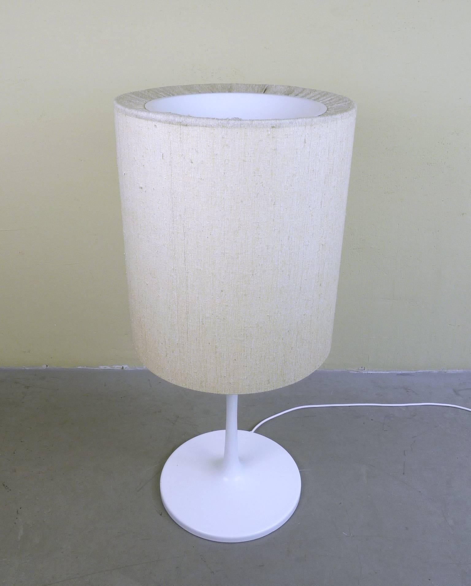 This floor lamp was made in the 1960s by German manufacturer Staff Leuchten. The white tulip base features a beige fabric shade. The lamp features four E27 sockets on the inside and a separate E27 light on top. The lamp is in very good original