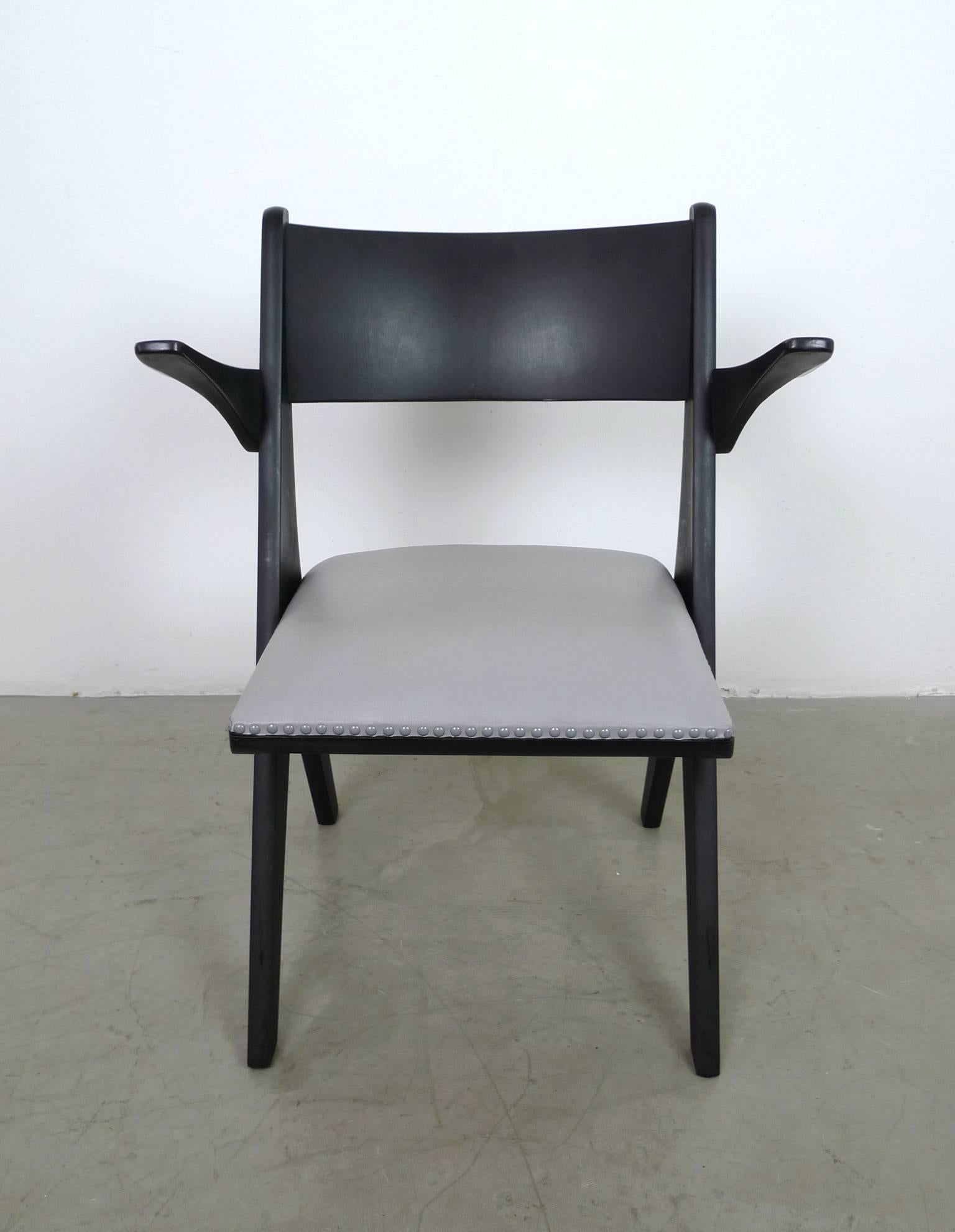 Model penguin armchair from the 1950s designed by Carl Sasse and produced by Casala in Germany.
The black stained beech frame holds a vinyl-covered seat cushion in grey, which is fastened with ornamental nails.
This chair is in very good vintage