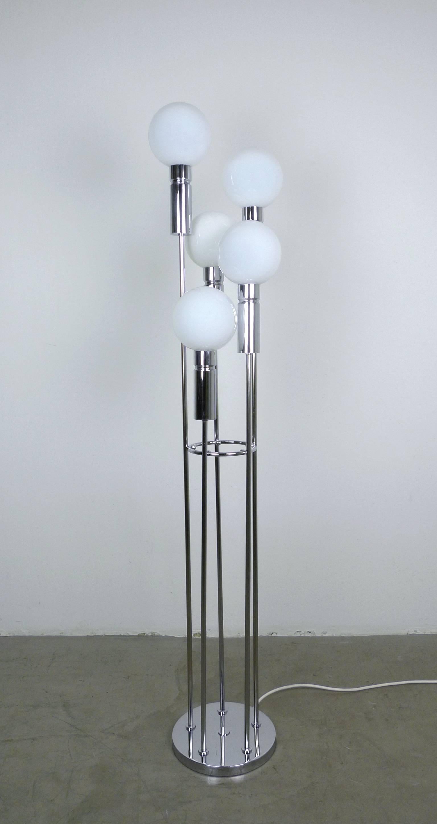 This floor lamp has a round base plate and chrome-plated metal rods, at the ends of which there are white glass spheres in different heights. Each glass ball is illuminated by an E 14 socket. The light intensity can be infinitely regulated by the