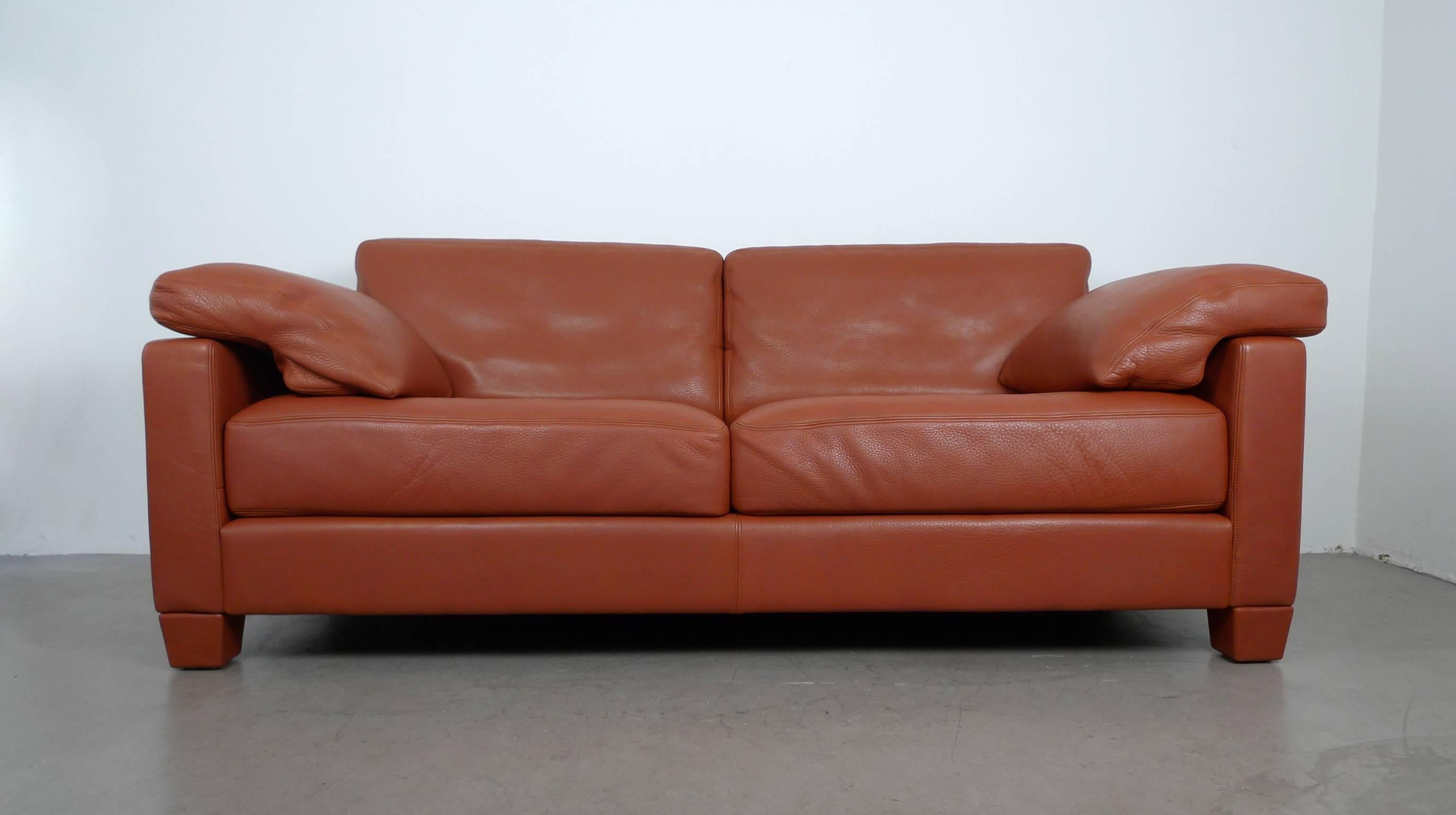 The 2 1/2-seat sofa model DS-17/123 was produced by Swiss manufacturer De Sede. The design was created by the In-House Design team in 1989.
Structure, feet, and cushions are upholstered in thick cognac-colored leather, which shows a pronounced