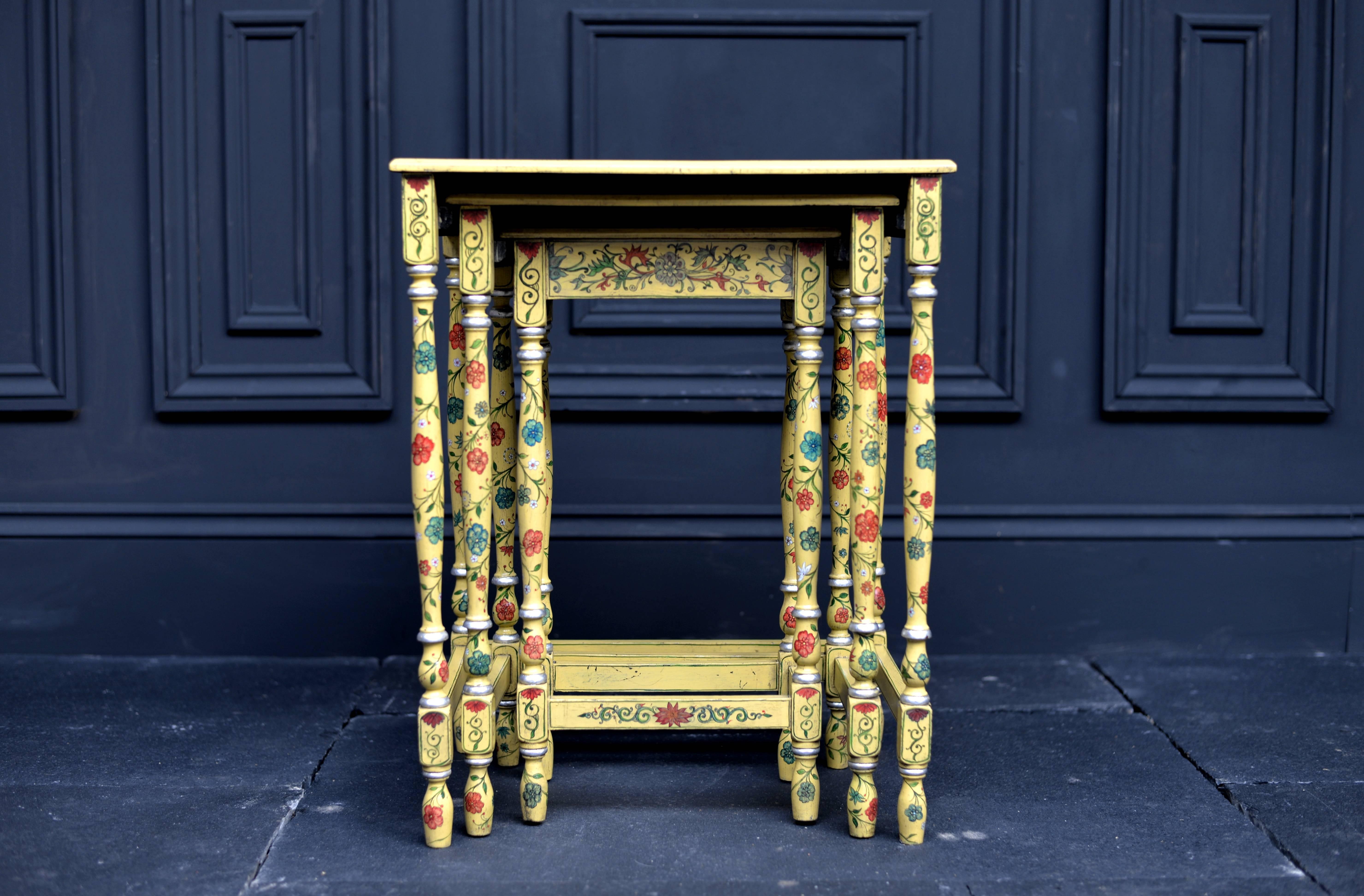 This is a rare antique nest of three occasional tables dating to circa 1890. With a Japanned finish of exquisite yellow tones, each table is beautifully decorated with a different scene on the top surfaces and floral decoration to the turned legs.