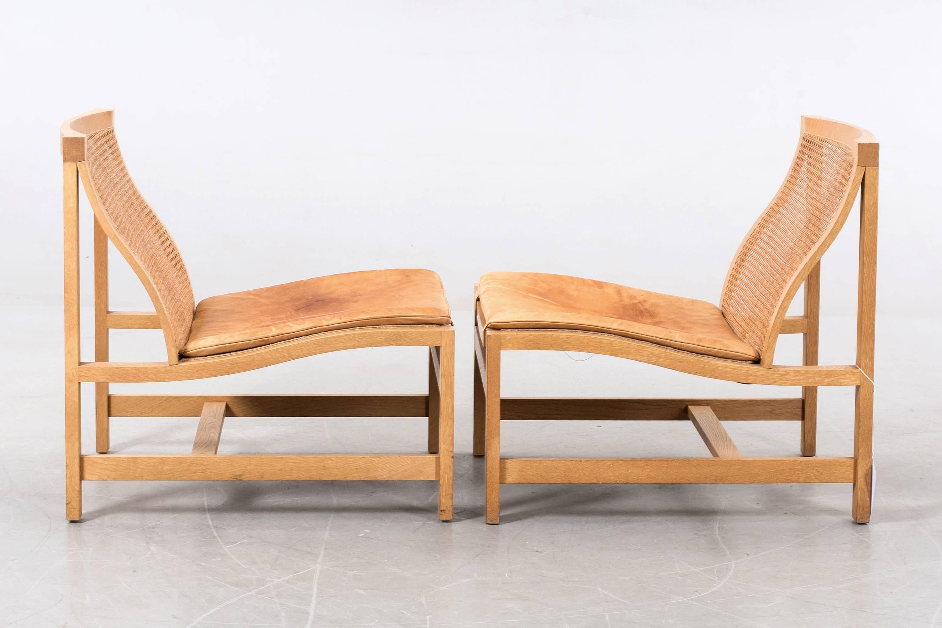 Pair of lounge chairs designed by Rud Thygesen and Johnny Sorensen.
Oak frame, rattan seat and back, cushion in light brown leather.
Thygesen & Sorensen won first prize in the 1969 competition held by the Copenhagen cabinetmakers' guild.
This