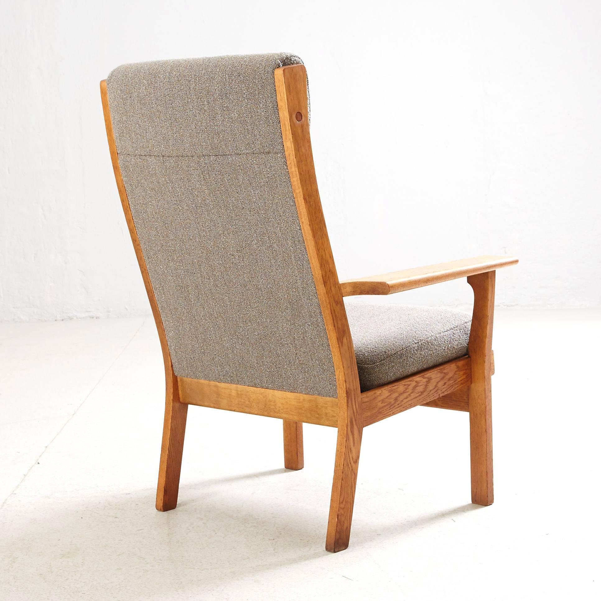 Rare and minimalistic high back lounge-chair designed by Hans Wegner and produced with outstanding craftsmanship by GETAMA in the 1970s. 
Made in natural oak and very fine grey upholstered.