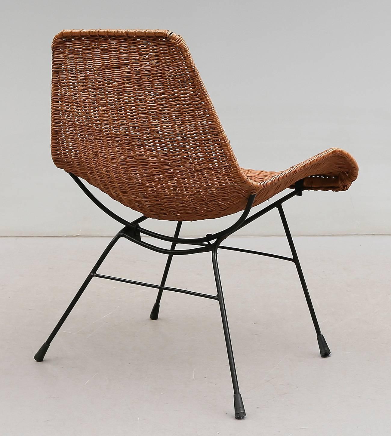 Rare easy chair model designed by Swedish modernist architect and designer Kerstin Hörlin-Holmqvist in early 1950s, manufactured in wicker and black iron.
