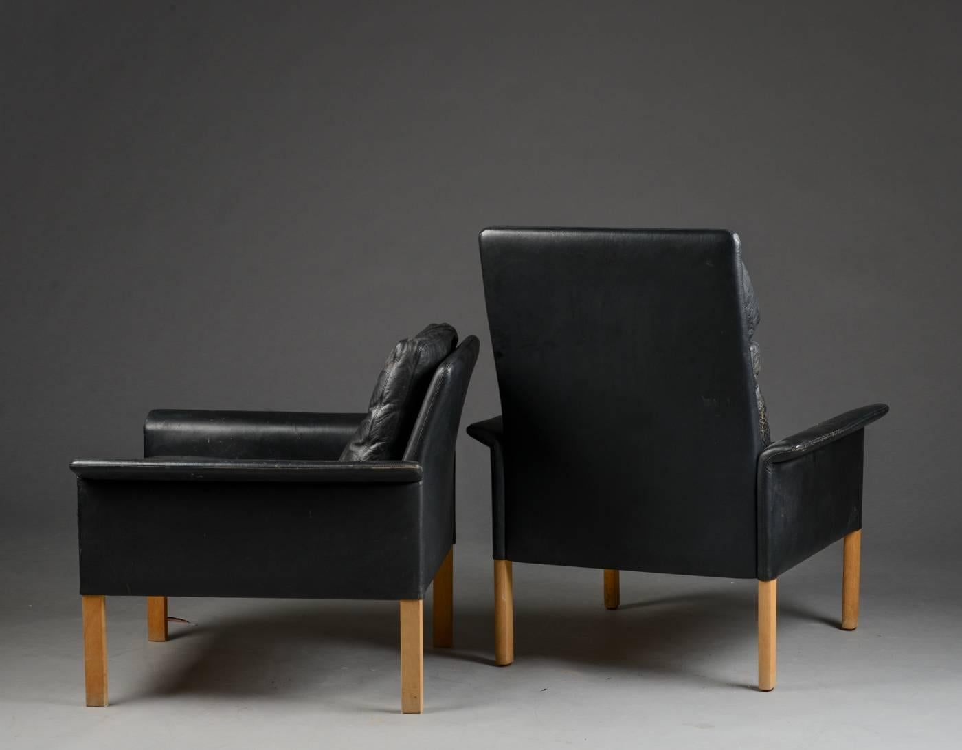 Pair of Danish Mid-Century lounge chairs and ottoman designed by Hans Olsen for Brande Mobelfabrik. Upholstered cushions and frames in original black leather. Raised on solid oak legs.