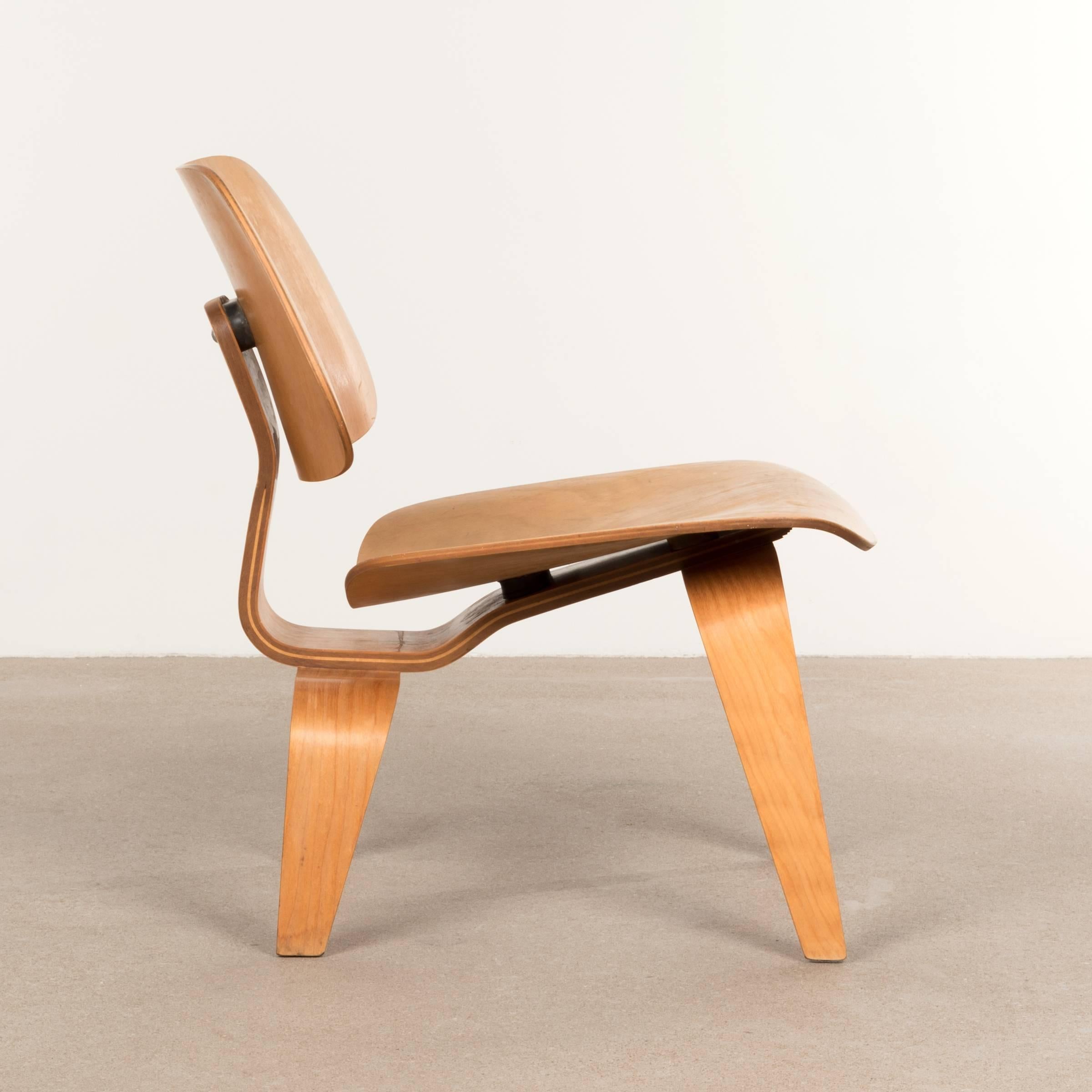 Iconic LCW lounge chair in maple plywood. The veneer and chair is in good condition with nice patina. Light traces of us, but no damage or distractions. Early Herman Miller edition after they took over the production from molded plywood