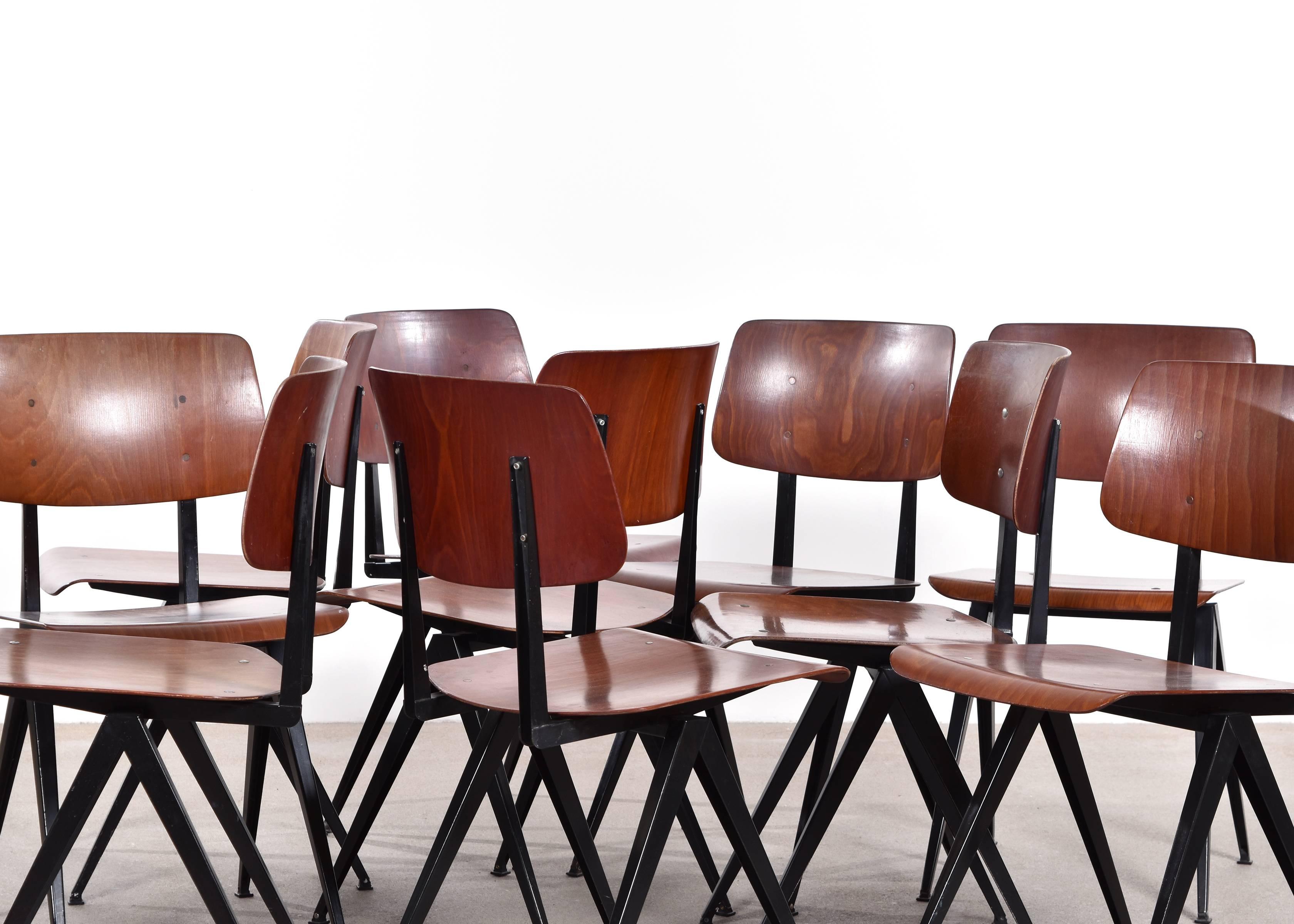 Vintage industrial Galvanitas S16 plywood chairs. Black or very dark brown steel frames and dark red brown plywood (synthetic) seats and back rests in good condition. Slight traces of use. Signed with impressed manufacturer's mark.

 