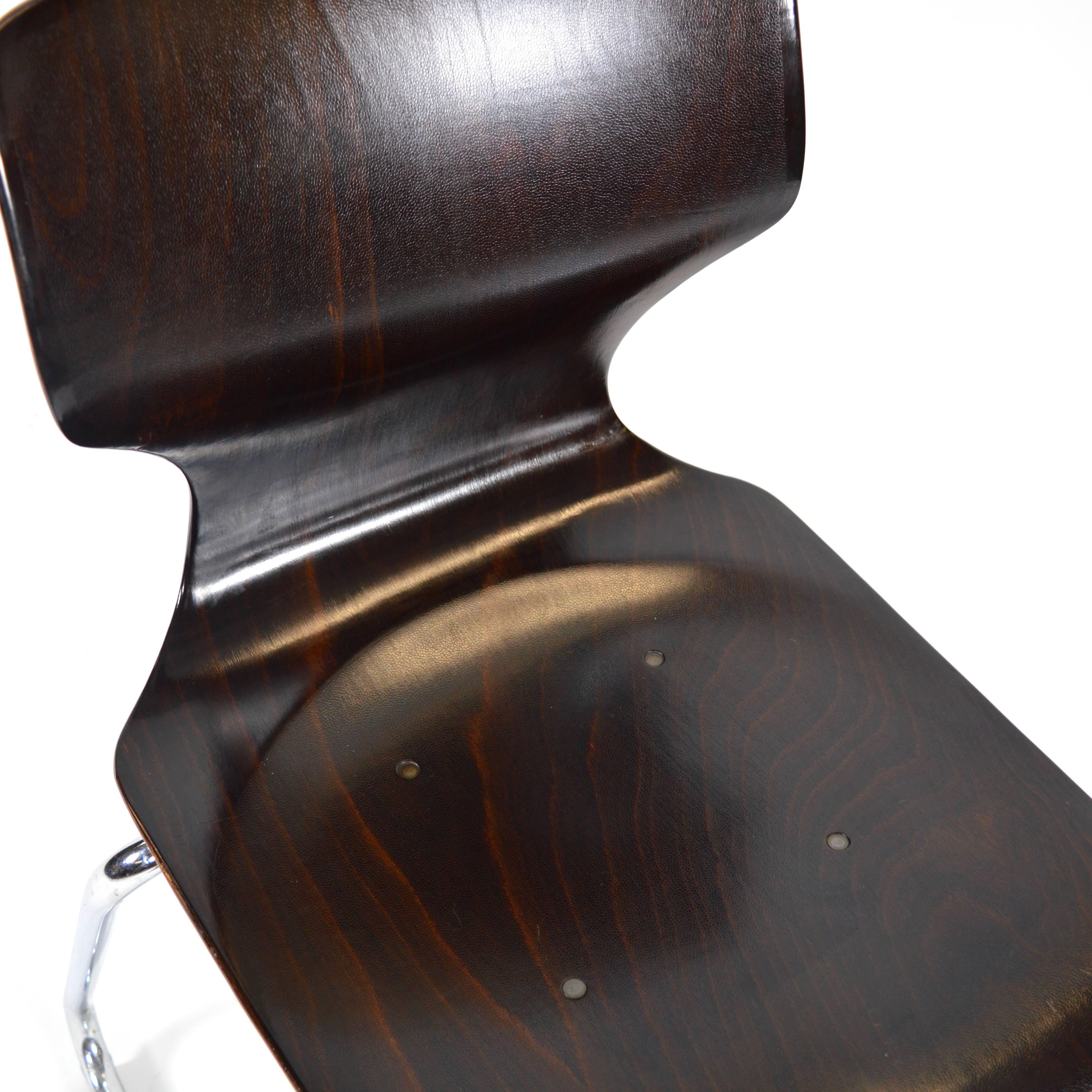 This is the popular model.

Elmar Flototto Industrial school chairs with pagholz seat and chrome tubular base. Each chair is stamped in the back with the Flototto company logo.
The chairs are stackable.
Colour: Dark brown.
In good condition.