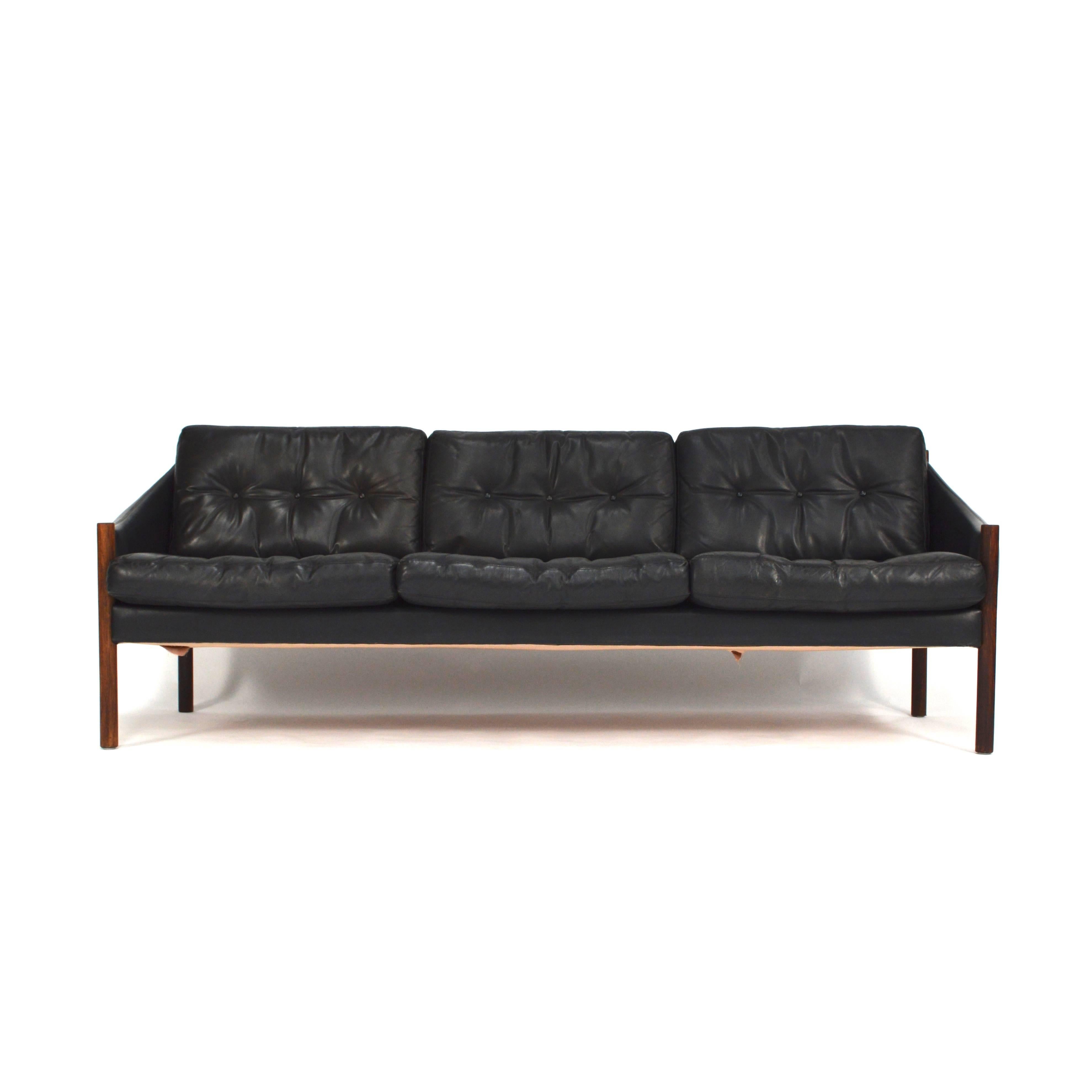 Beautiful and very comfortable three-seat sofa attributed to Arne Norell from the 1960s.
The black leather is still in very good condition with some nice signs of age and use.
The legs are made of solid rosewood.
The armrests are curve