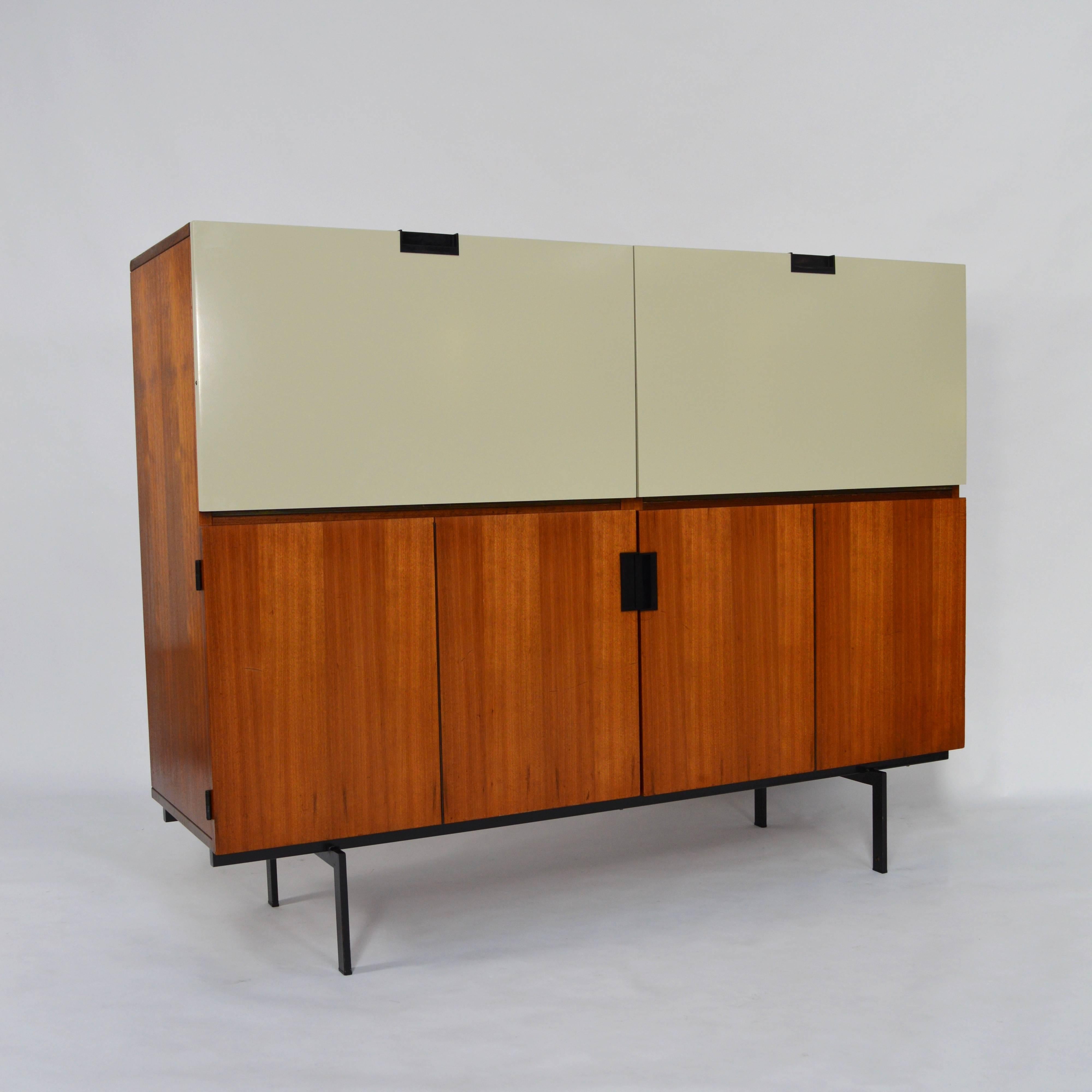 CU07 'Japanese Series' cabinet by Cees Braakman.
The cabinet holds a dry-bar part for bottles and glasses and a desk part with envelope storage and a small drawer.
Teak and off-white doors (original colour) with black metal base.
In very good