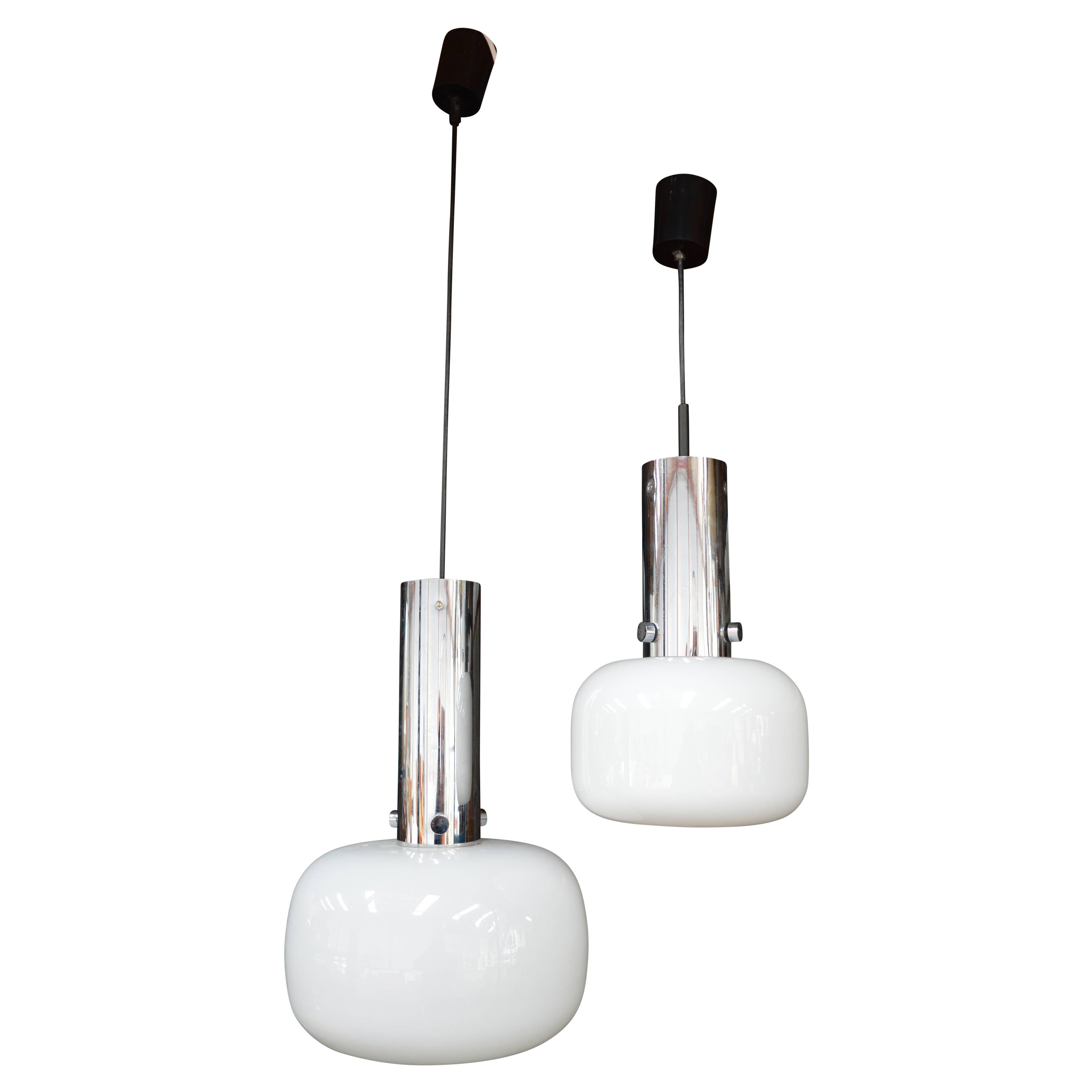Pair of space-age Glashütte Limburg pendant lamps made of opaline glass and chrome, Germany, 1970s.
The E27 socket is recessed far into the chrome tube so that the light source itself isn't visible thereby providing an indirect down light in the