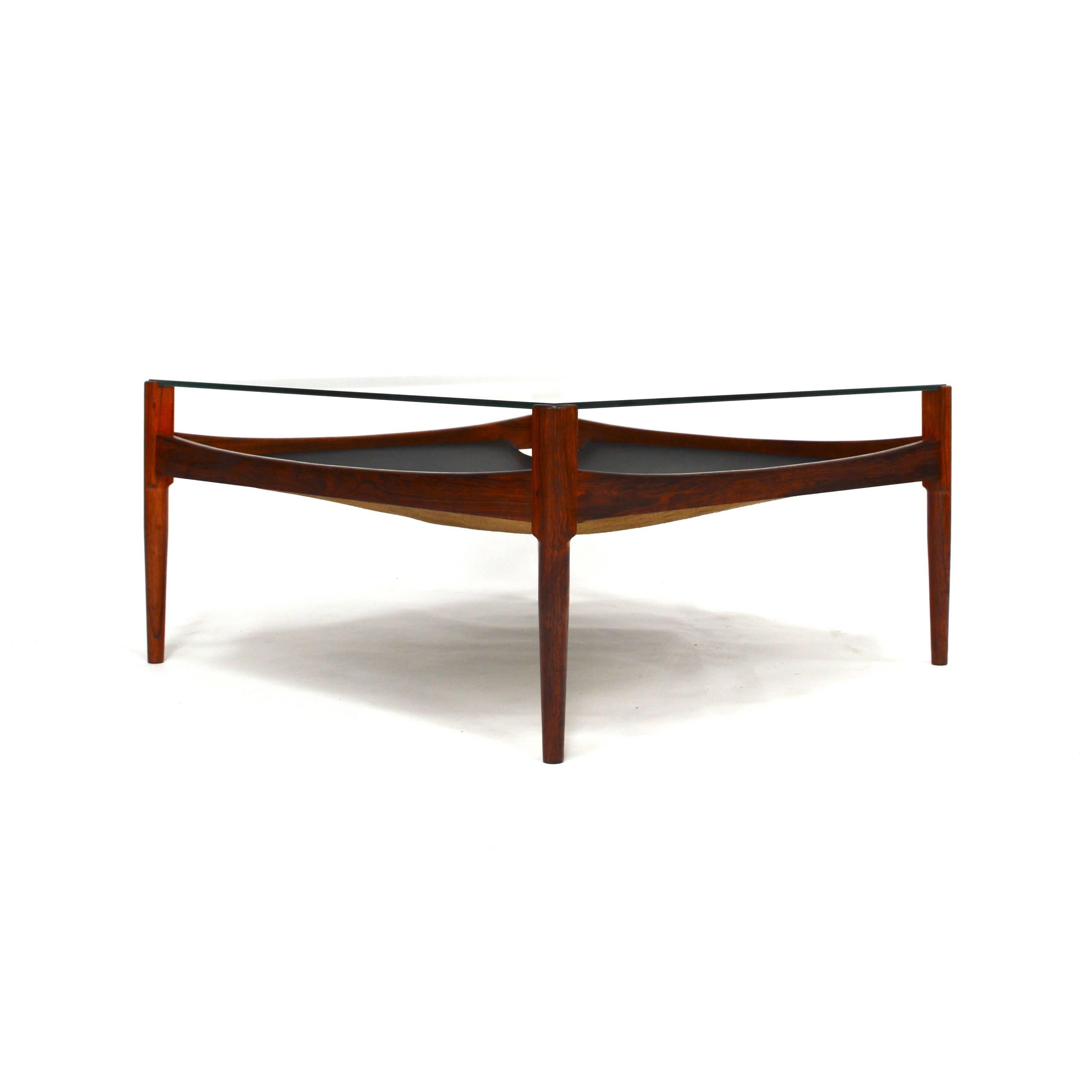 Rare coffee table by Kristian Vedel for Soren Willadsen in Denmark. 
The table is made of rosewood, glass and a black leather magazine rack. 
It is in excellent condition.