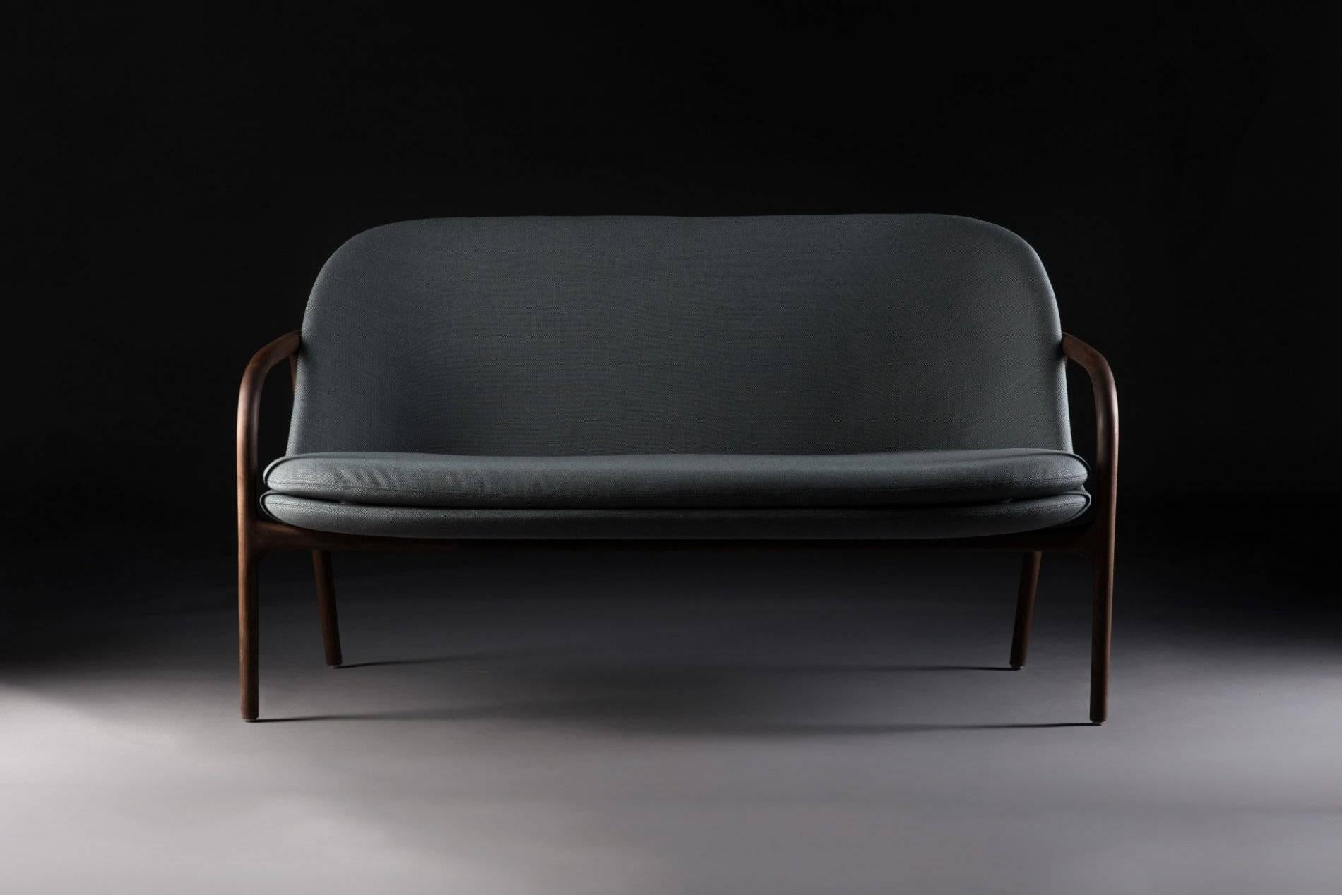 Absolutely gorgeous sofa by Artisan. Phenomenal handcrafted wood work. This is the best of the best an can be ordered in multiple types of wood and fabric. 
Kvadrat, De Ploegstof and Leather.
European walnut, American walnut, oak, maple, elm,