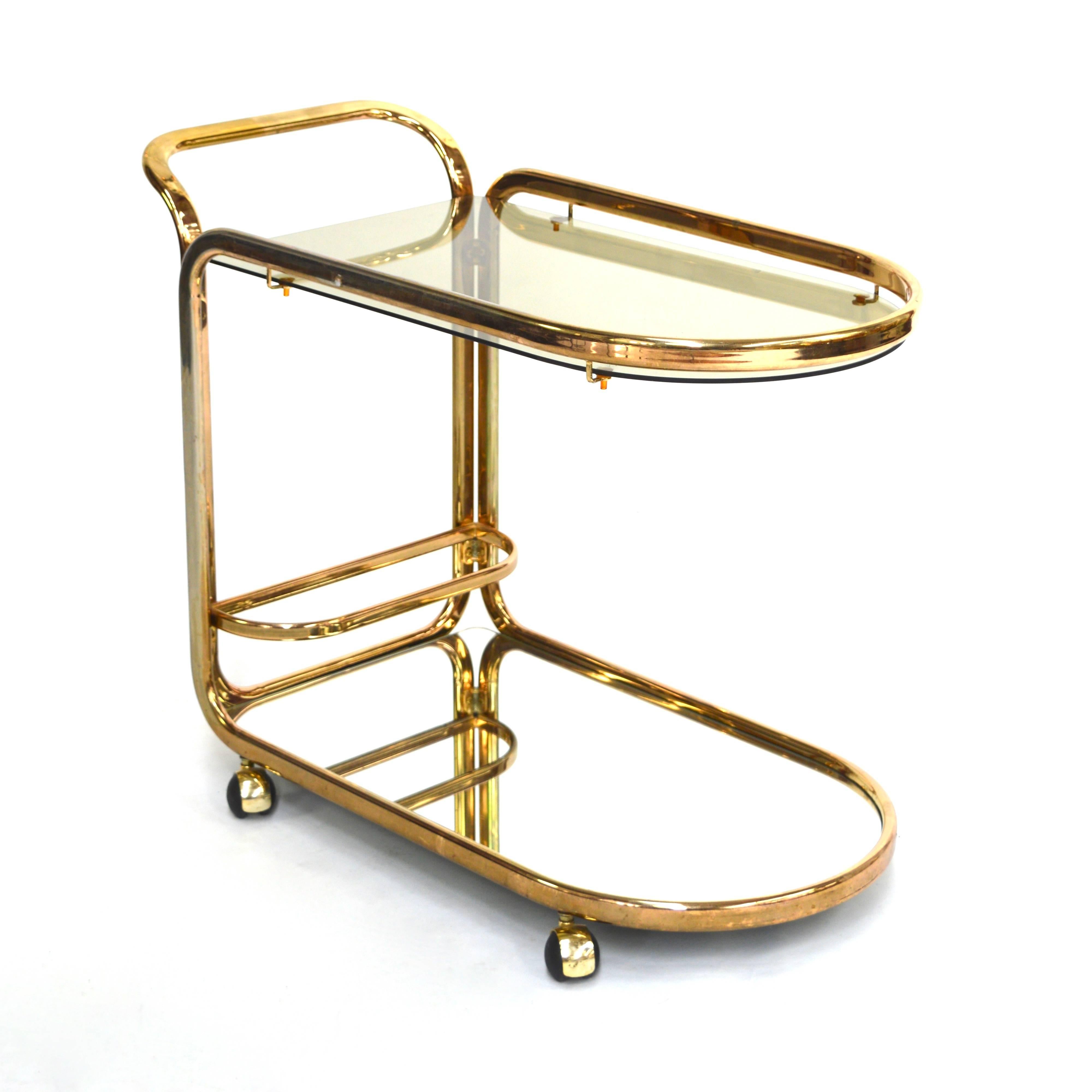 Very nice bar cart with tubular gold colored metal / mirror glass / smoked glass.
It is in good condition but has some normal age related signs of wear and fading.