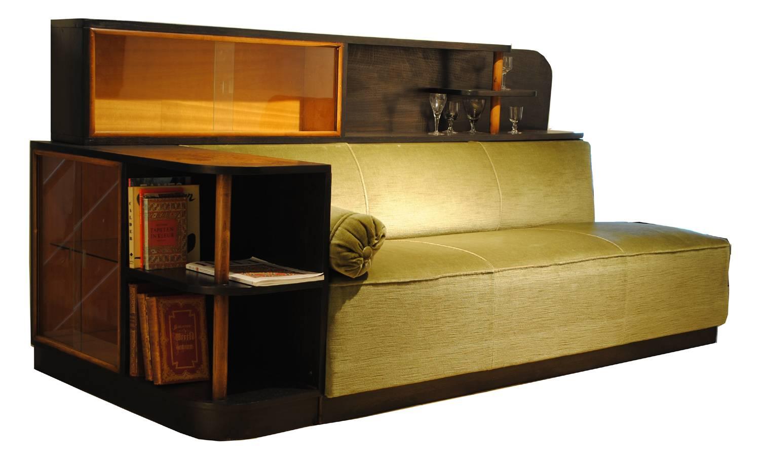 Great Gatsby style sofa.
Very nice and rare Art Deco sofa with integrated cabinets and shelving that can be used as bookcase and bar.
It has a nice green velvet upholstery.

Size in cm:
All W x D x H 222 x 93 x 105 cm 
Sofa W x D x H 180 x 57