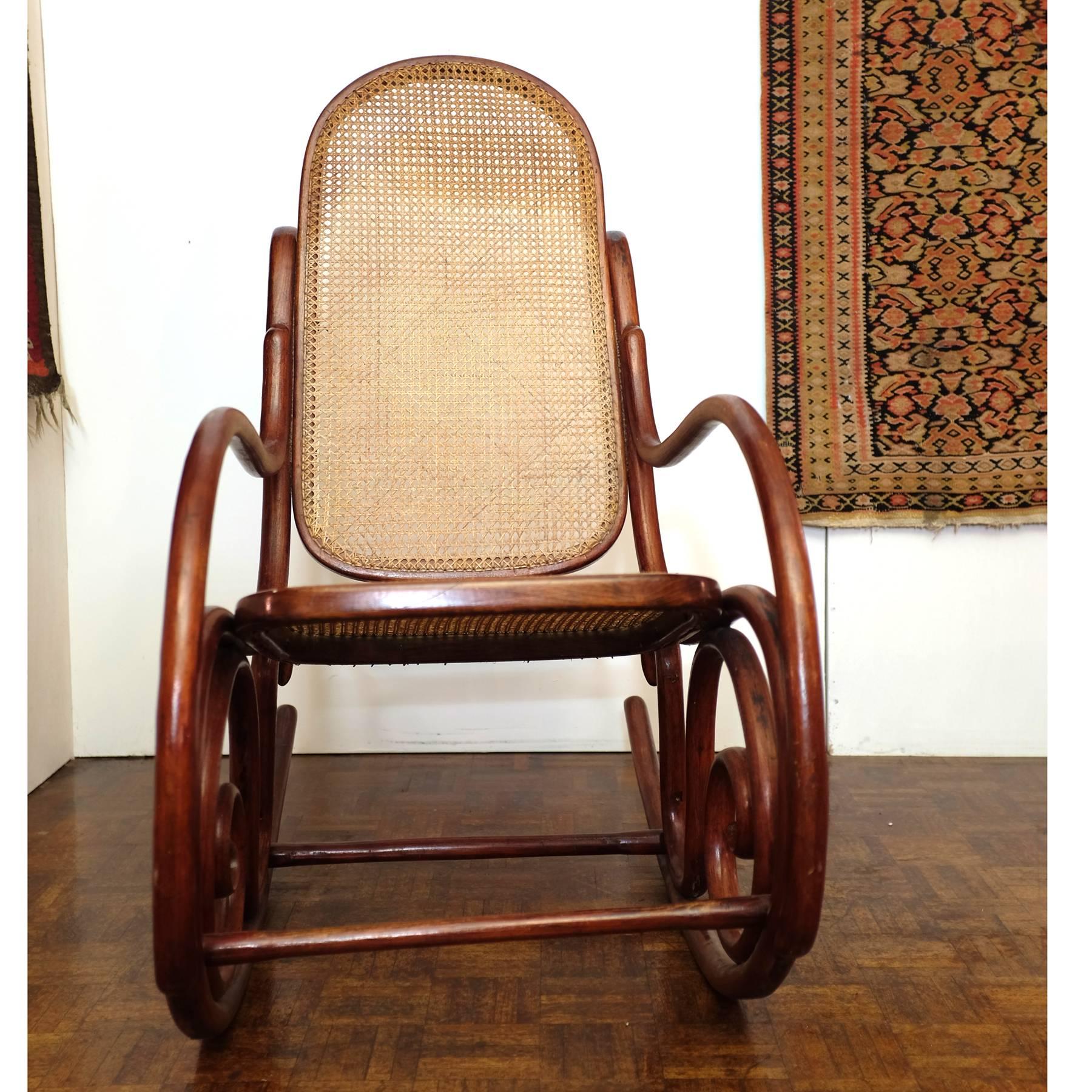 Thonet rocking chair made of stained beech bentwood and cane. In good original condition.
 