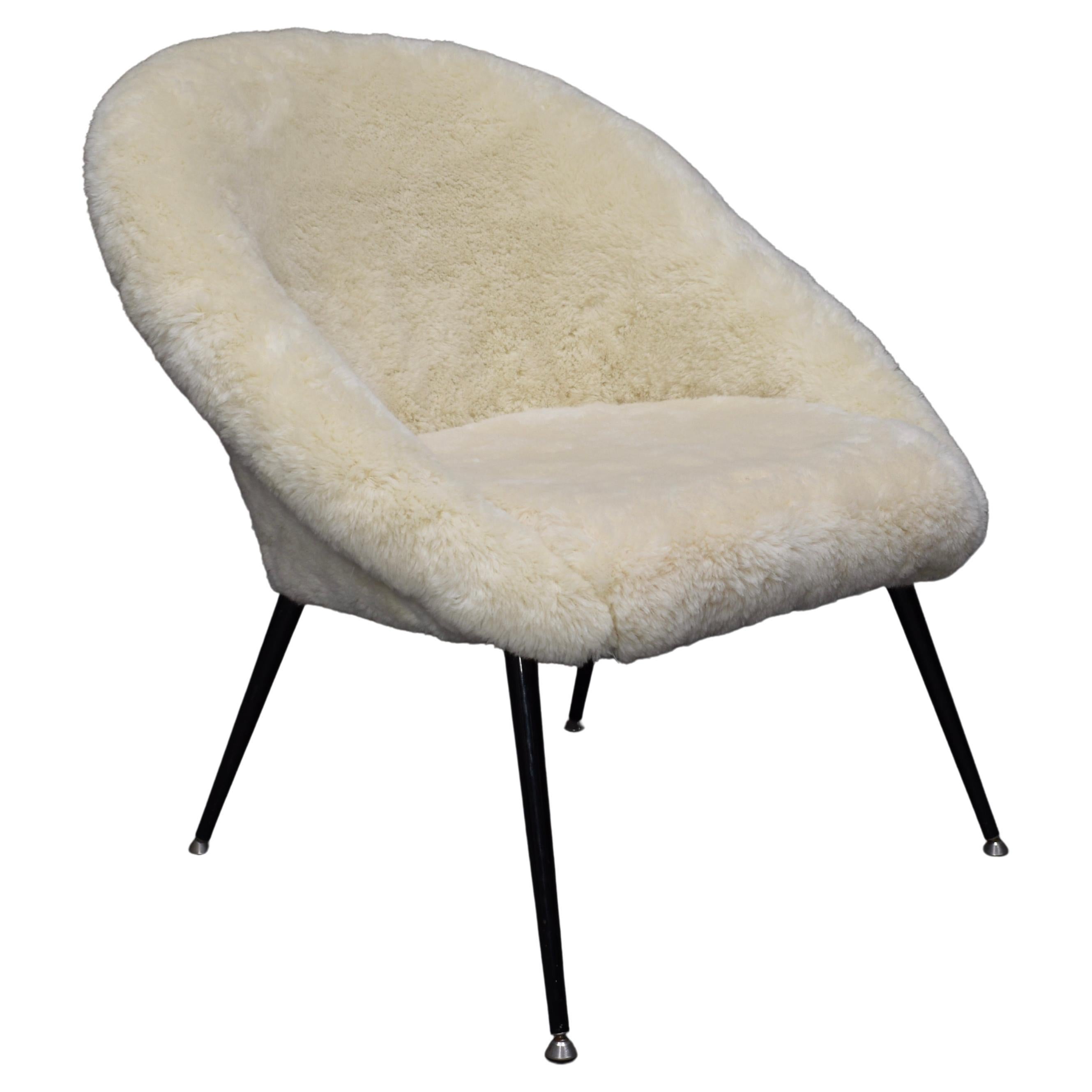 Elegant armchair new upholstered in thick Sheep wool.
We have three chairs available.
The chair is labeled August 3d 1970.
The legs are made of black lacquered steel with chrome feet. 

Designer: in the manor of Fritz Neth
Manufacturer: