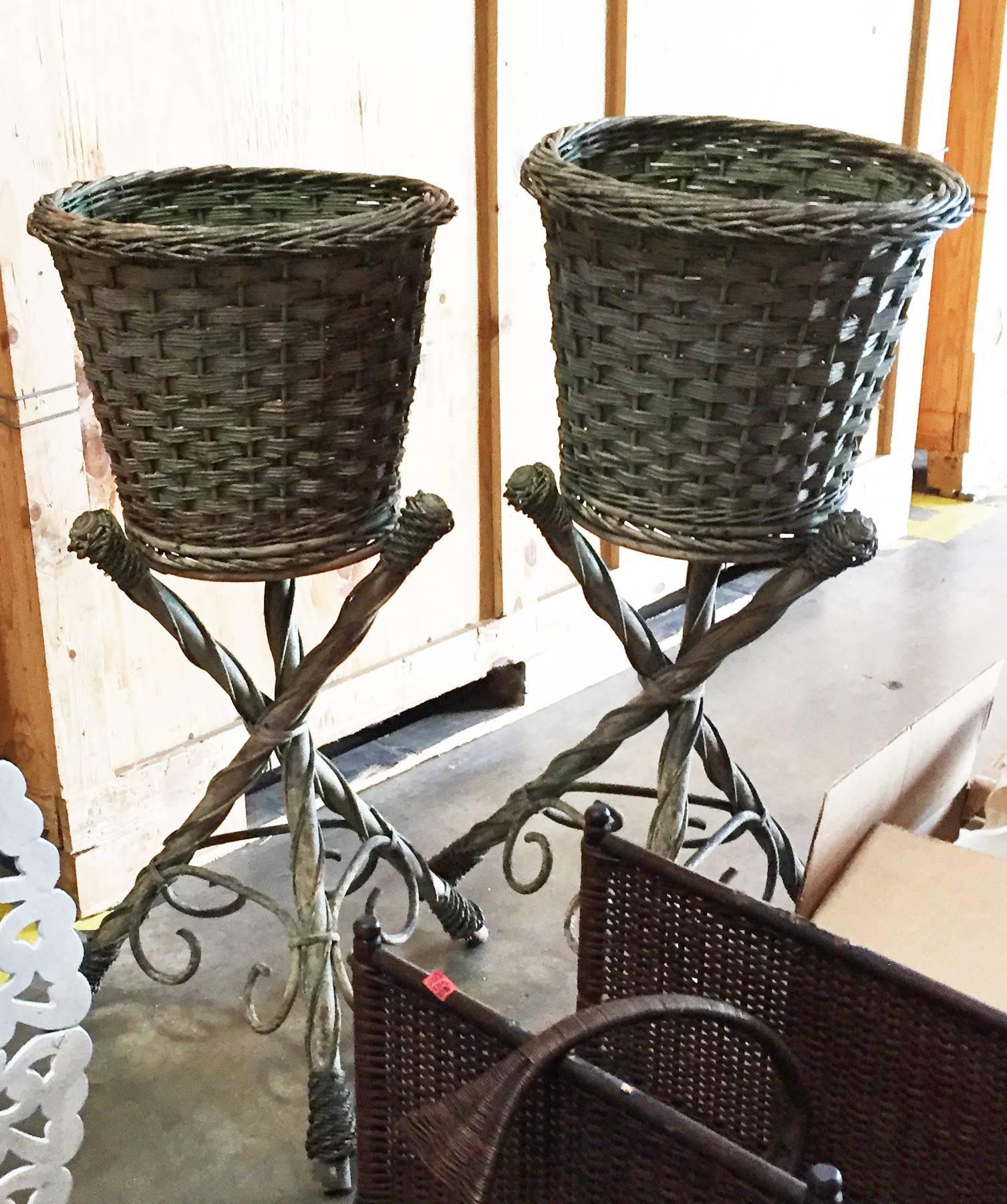 Victorian wicker pair of garden baskets on tripodal bases,
painted green, each of the baskets of straight-sided tapering cylindrical form under a raised band at the upper rim, on three straight faux branch legs, with scrolls toward foot.
(The