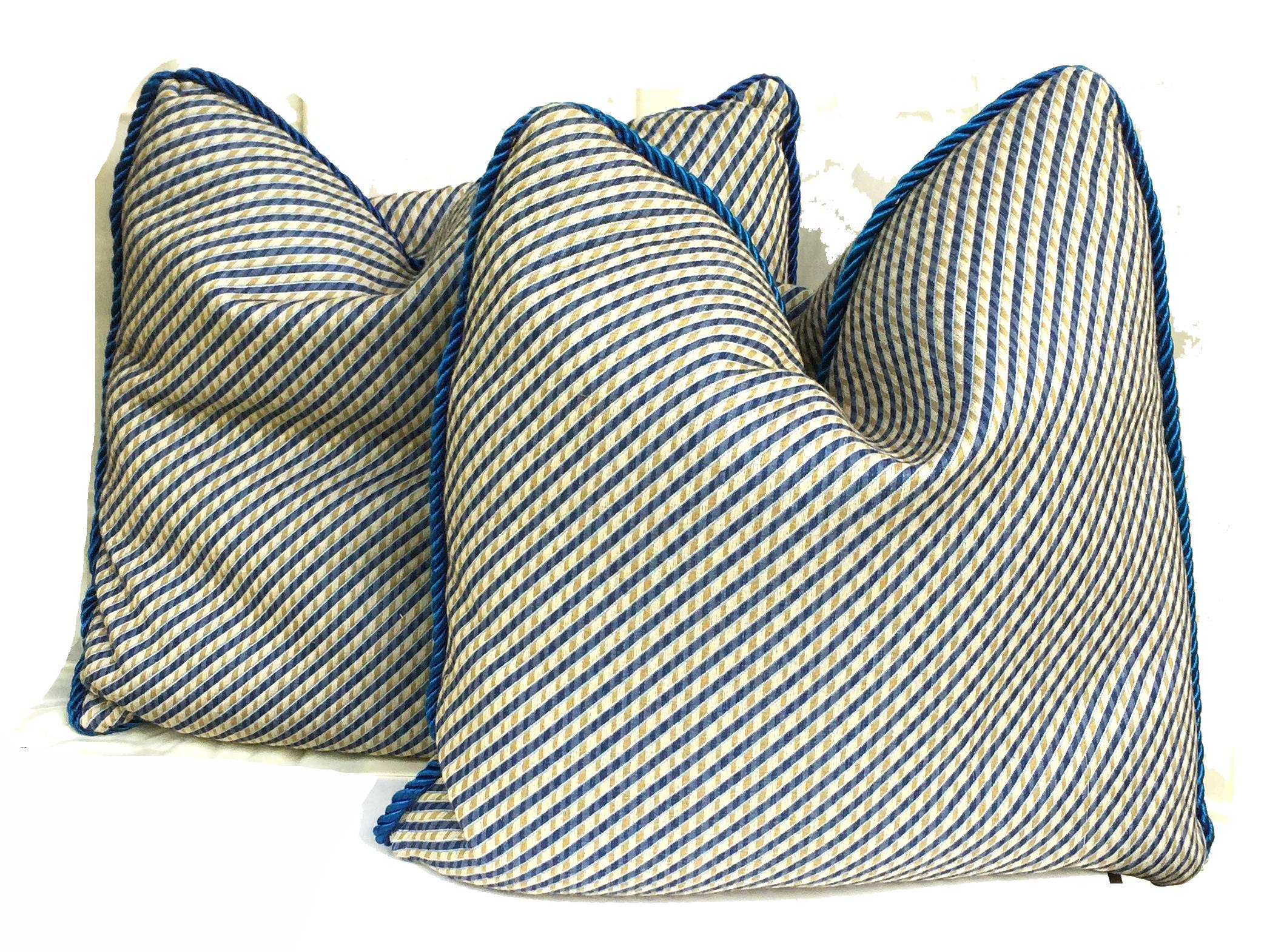 Vibrant pair of accent pillows with down fill, the front and back with diagonal patterning in Chinese yellow - ocher and blue, heavy-weight cotton fabric, the edges with peacock blue silk rope-twist trim, 3/4