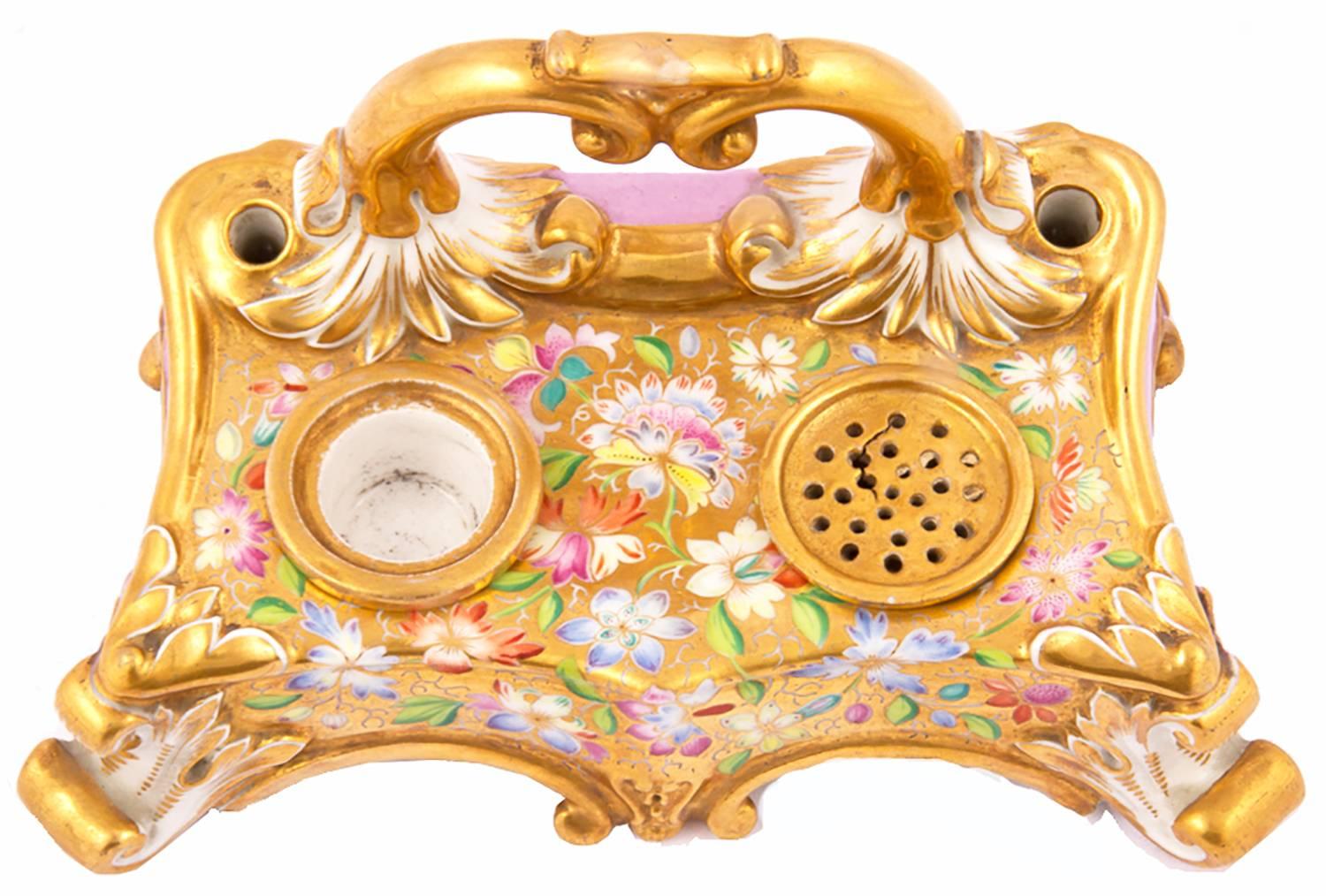 French Haviland Limoges porcelain scrolling quadrapodal rectangular ionkstand with gilt-molded handle, the gold ground painted with flowers, with sander and well, and two holes for pens. The rear of the stand painted with pink ground