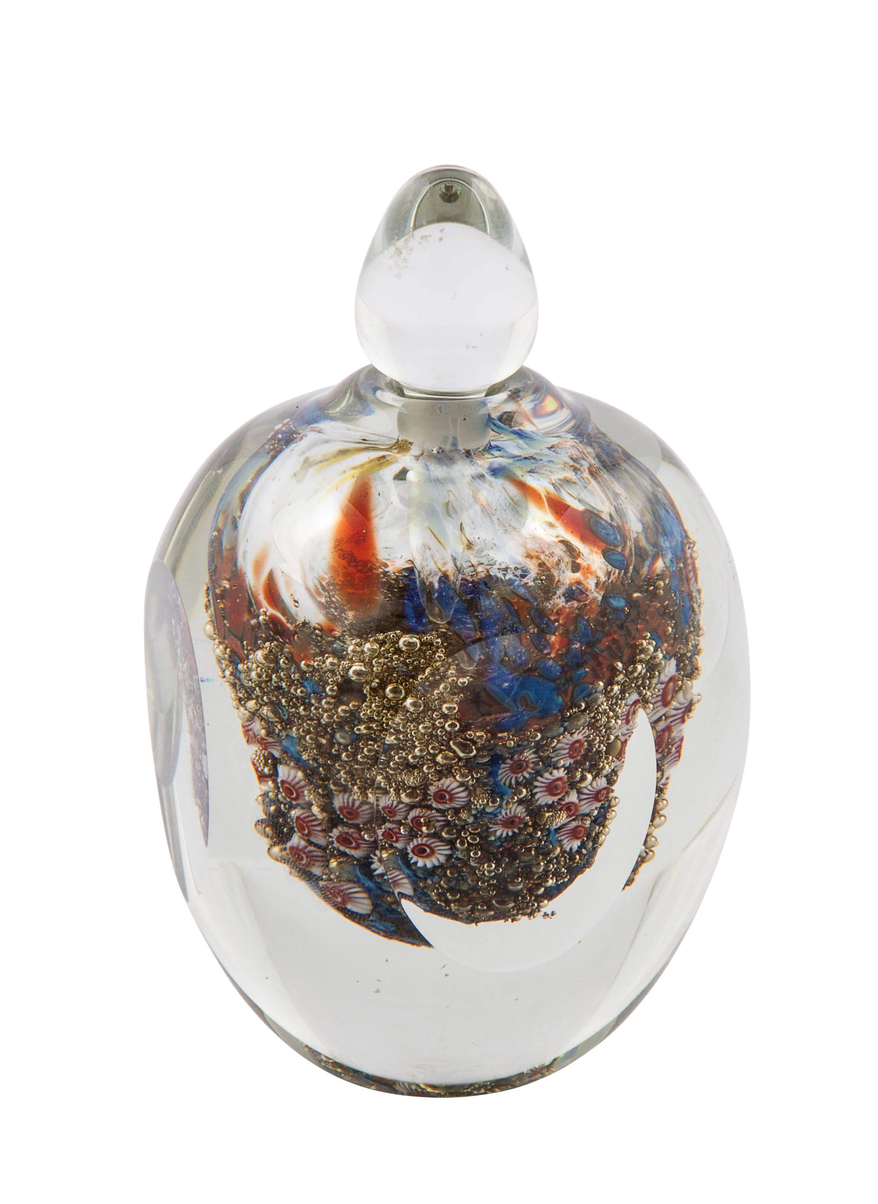 American Richard Satava studio glass scent bottle and stopper, of ovate from, cased as a paperweight, the interior with millifiori seaforms and corals, the ovoidal pointed stopper clear.

Signed to base R. Santoni and 005 86.
4 1/2
