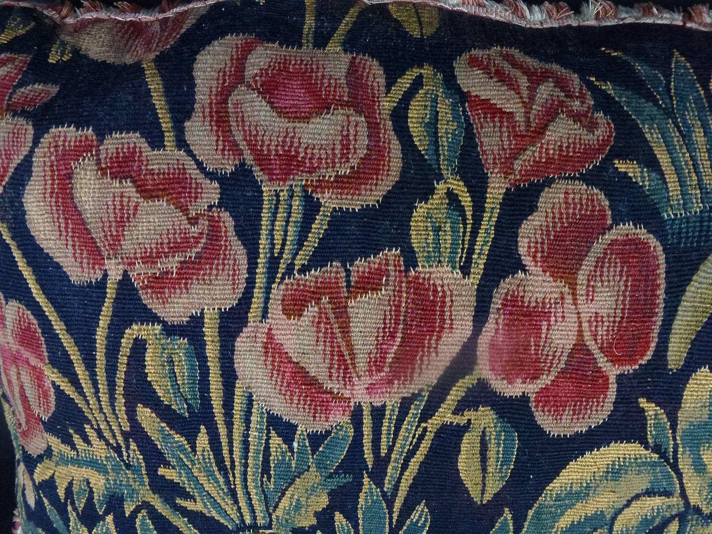 Tournai Gothic silk and wool tapestry floral pillow of rectangular form, the deep blue ground with red tulips on green stems, ferns, acanthus, and water reeds, trimmed with red edges, the colors very intense and well-preserved. The verso of natural