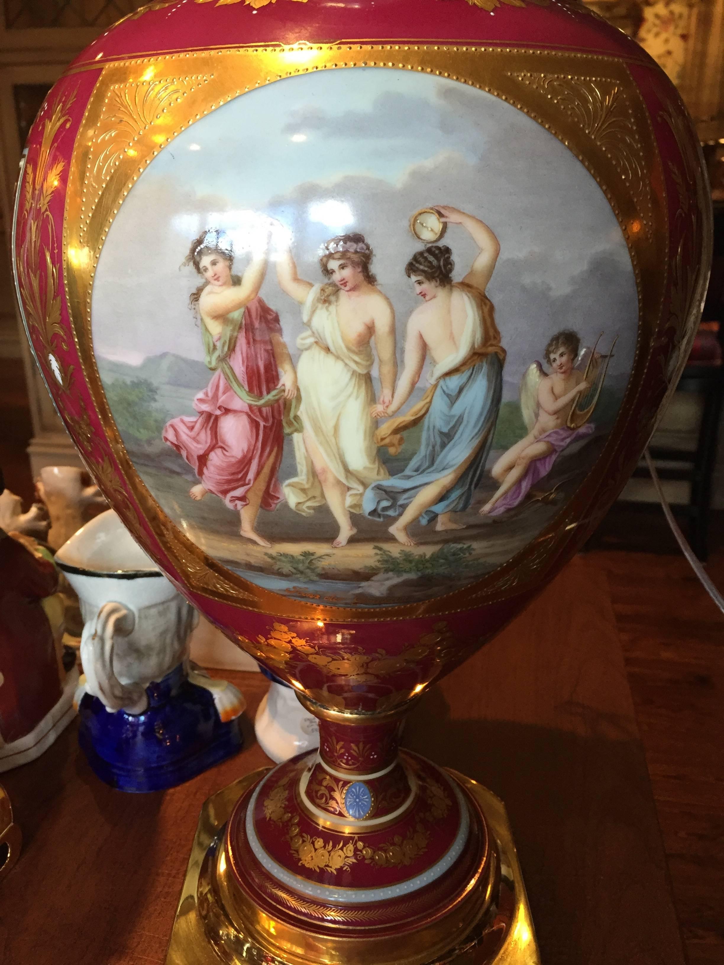 German porcelain Royal Vienna-style pair of large and fine cabinet vases, now with brass bases and lamp mounts, the pink or red globular bodies with flaring necks and socketed ankles over the spreading feet, with inset squares, rectangles and ovals