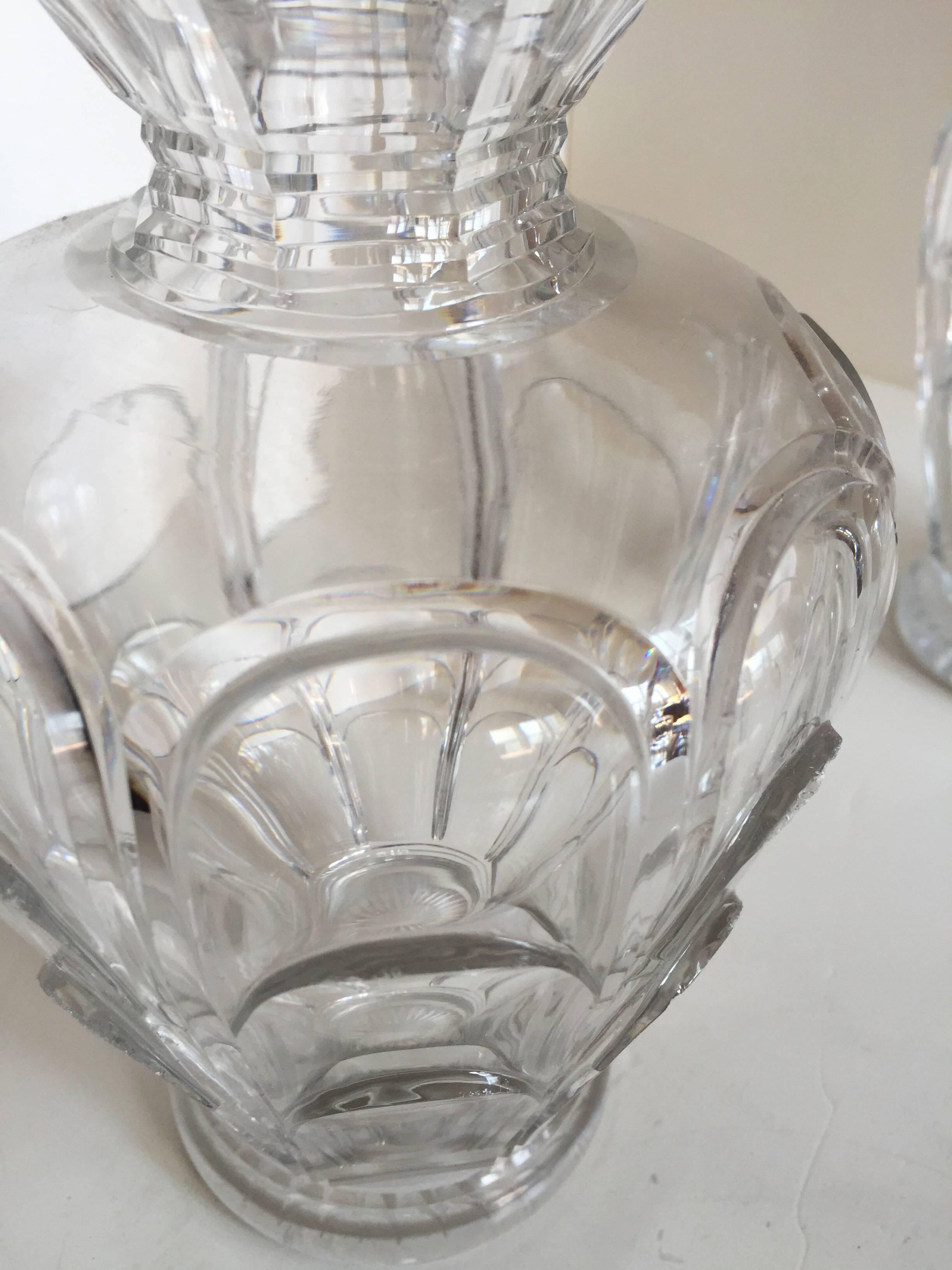 French cut crystal blown and molded glass pair of decanters, the flared mouths over elongated necks with two clusters of horizontal ribbing, a bulbous knuckle above the shoulders similarly ribbed, the tapering bodies under the high shoulders molded