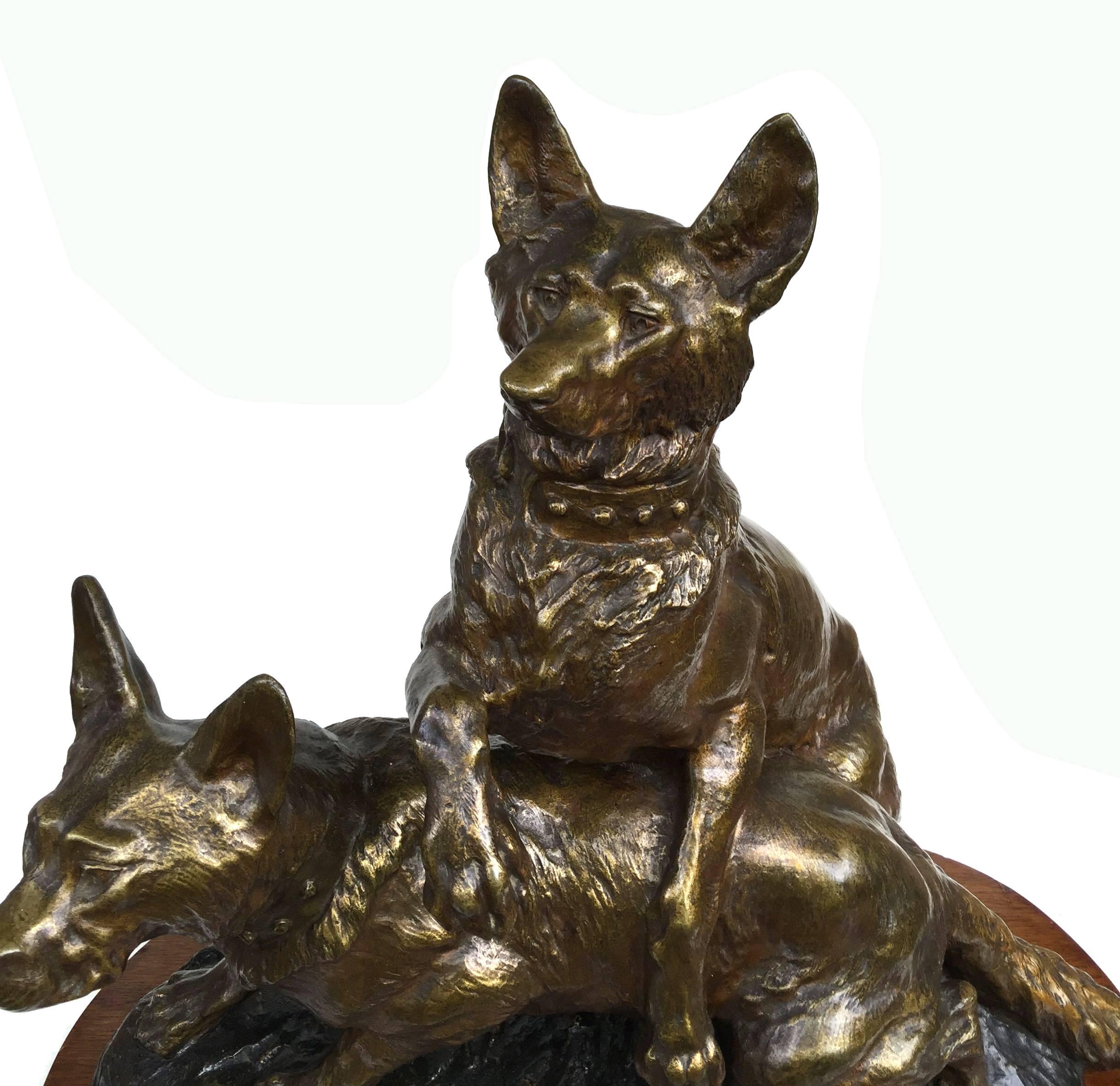 French Thomas Francois Cartier (1879-1943) bronze sculpture of two Alsatian wolf dogs, the female facing sinister, the male facing forward with one paw over her back, both at attention, listening. Signed Cartier, center front of the mounded