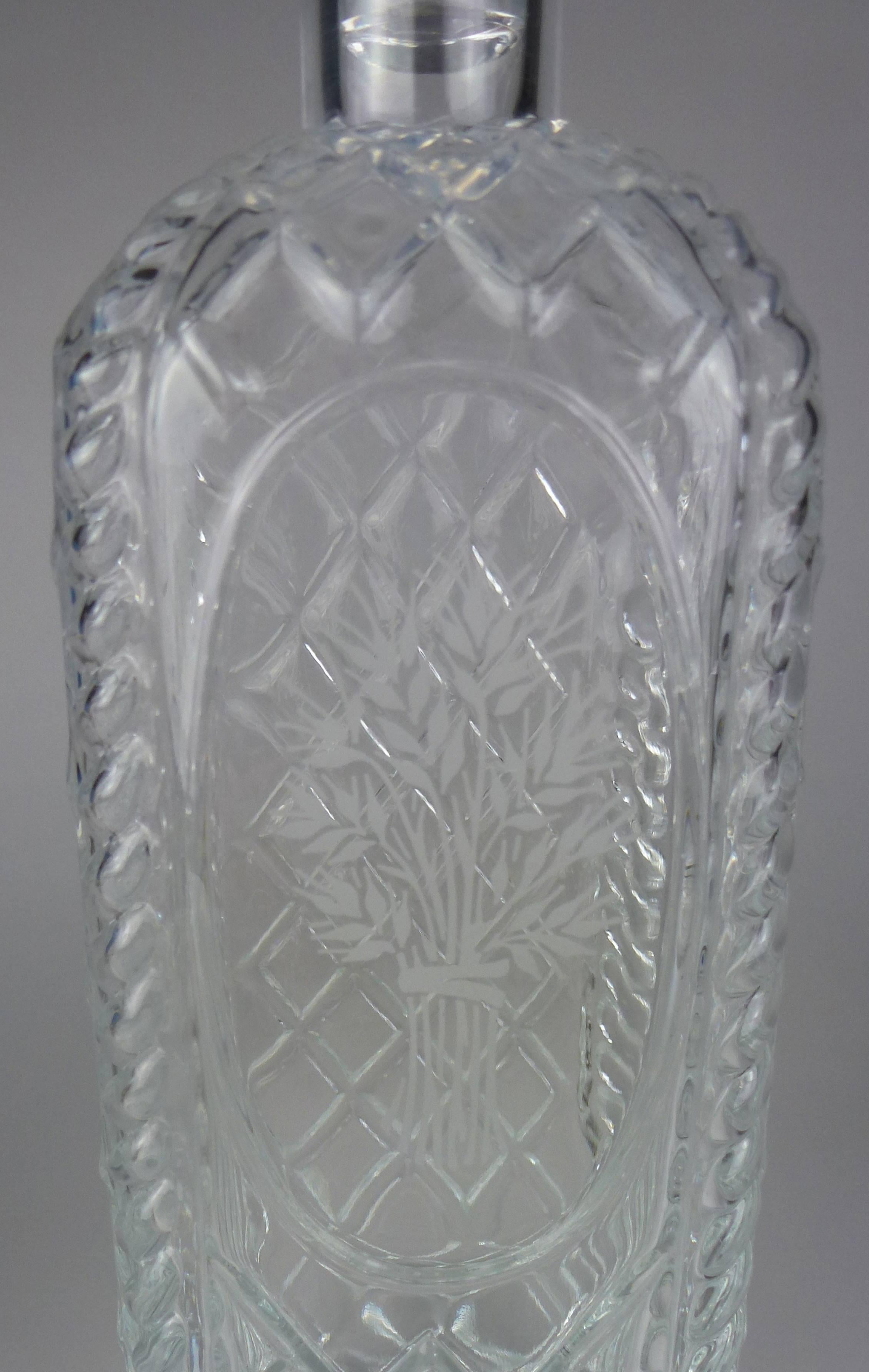 French rectangular glass spirit decanter and stopper, cut all over in the 'brilliant' style with diamonds and cables to the edges, one side engraved with a sheaf of rye wheat within an oval, with lapidary-cut mushroom-form stopper.

Marked Made in
