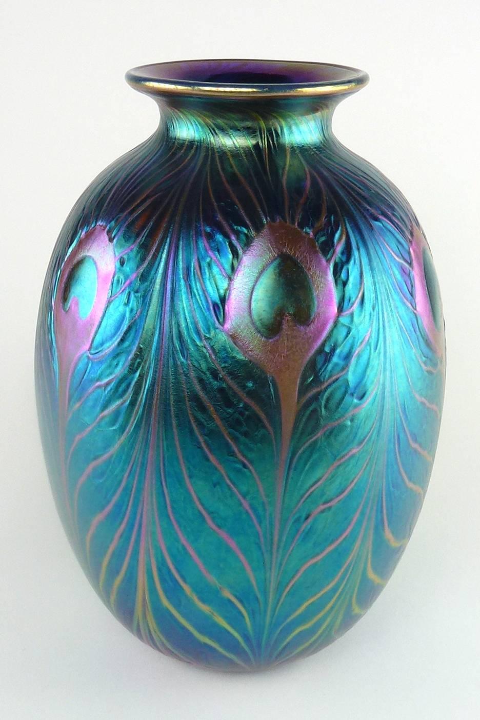 Charles Lotton iridescent blue peacock feather studio art glass vase, folded over rim, iridescent interior, studio polished base and pontil mark.

Signed 