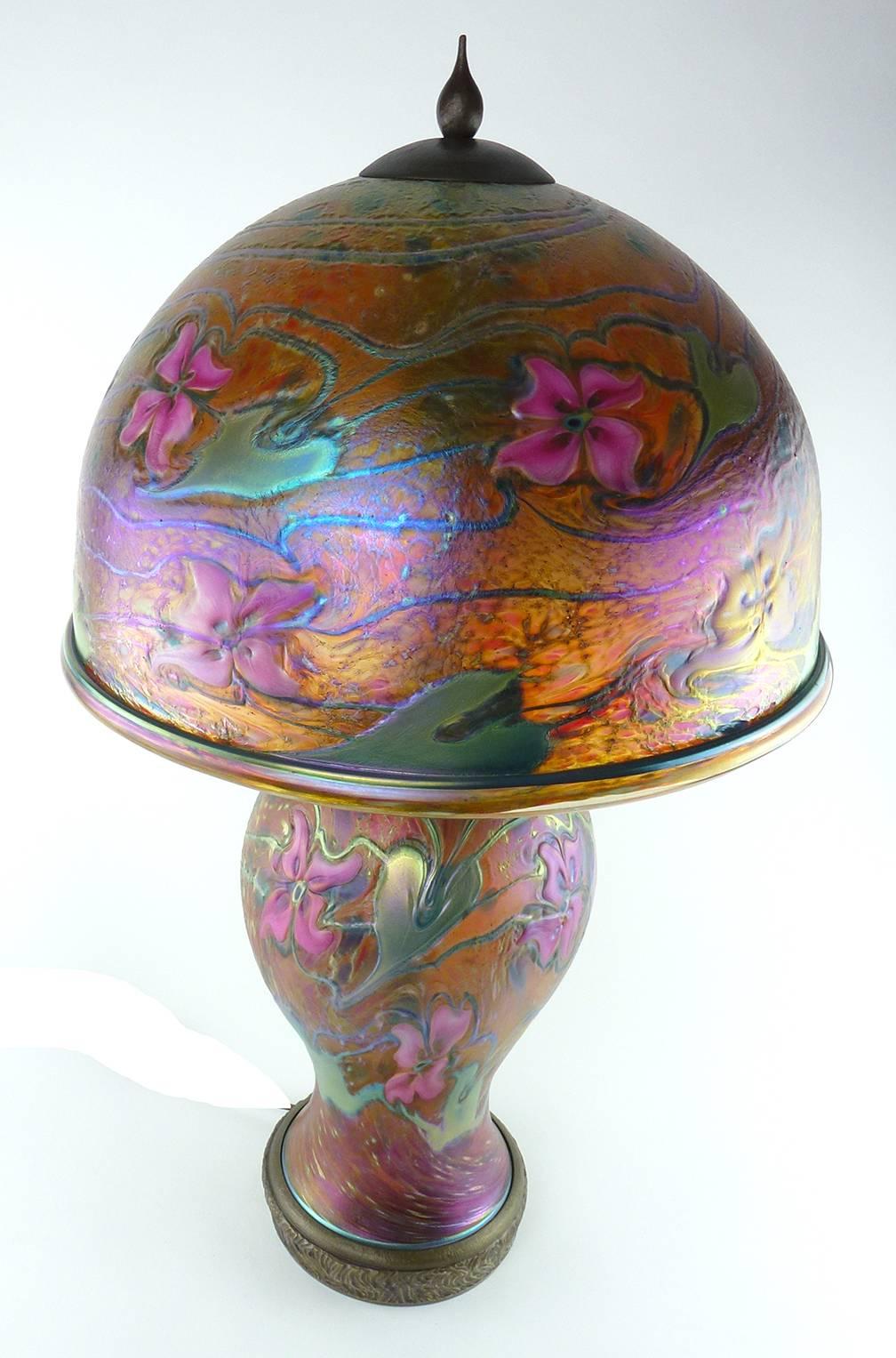 Charles Lotton Contemporary Studio art blown glass orange pink table lamp

Charles Lotton (B. 1935) Contemporary Studio art blown glass table lamp dated 2006, the dome-shaped shade over the baluster form base, with brass fittings, the glass of
