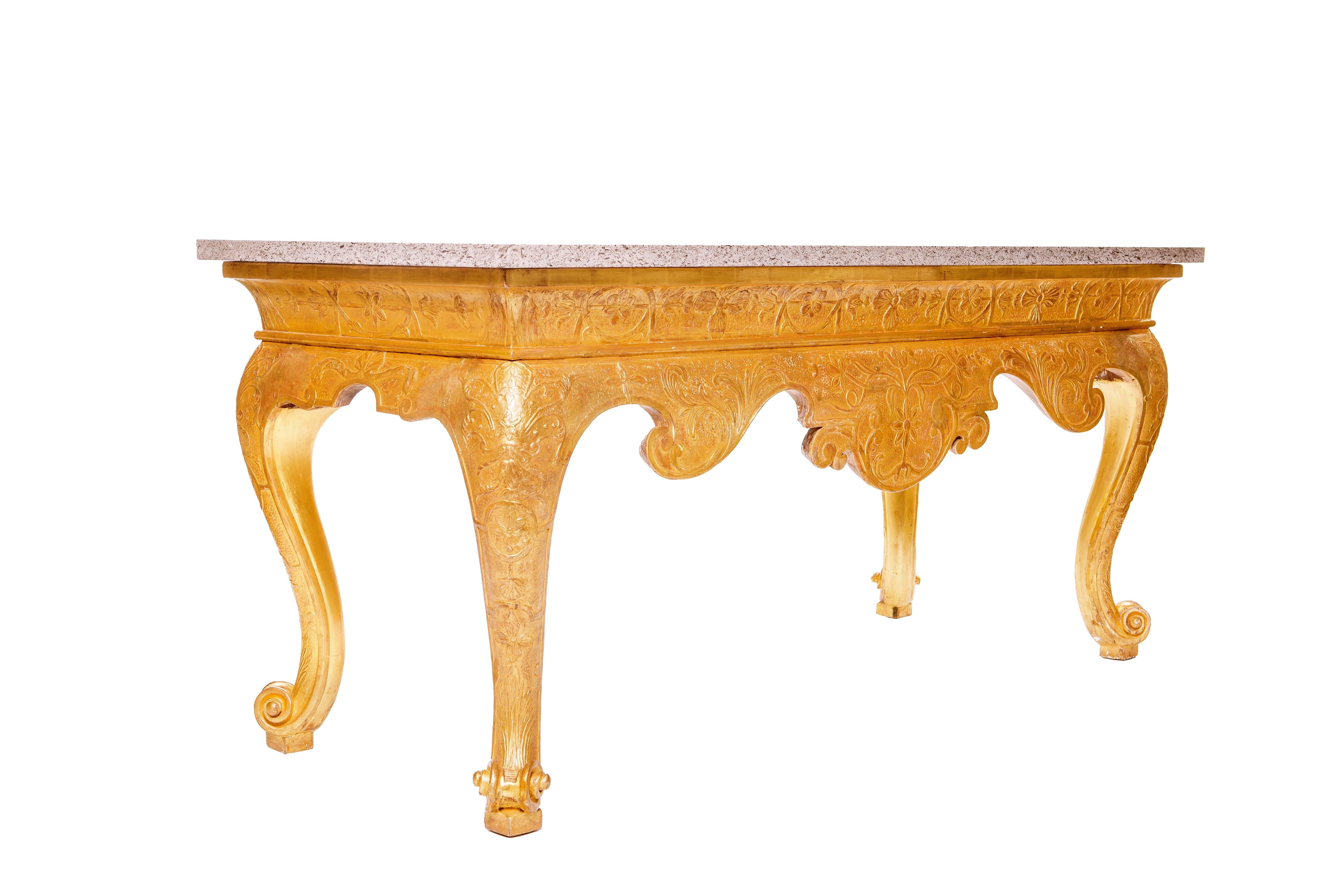 A fine early 18th century English Georgian gilt gesso strap work console of large portions, with a marble top, the base with elaborate raised floral strap work and deeply scalloped apron, supported by cabriole legs with scrolled feet.