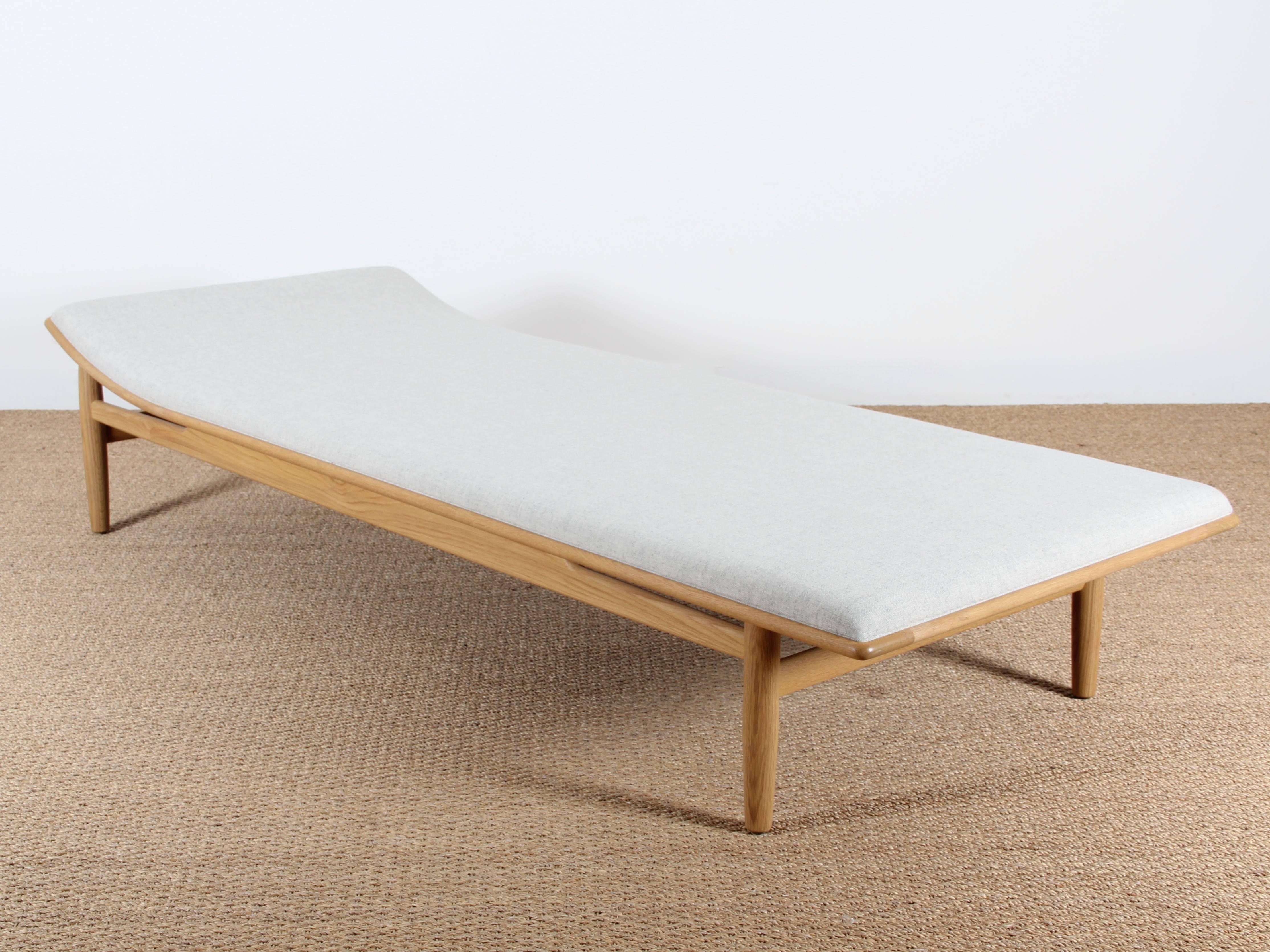 Kurt Ostervig day bed in solid walnut covered with wool fabric Divina light gray melange of Kvadrat.

First published in 1958 by Jason Møbler, this mythical day bed is now reissued by the Danish Matzform, licensing and authorization of rights