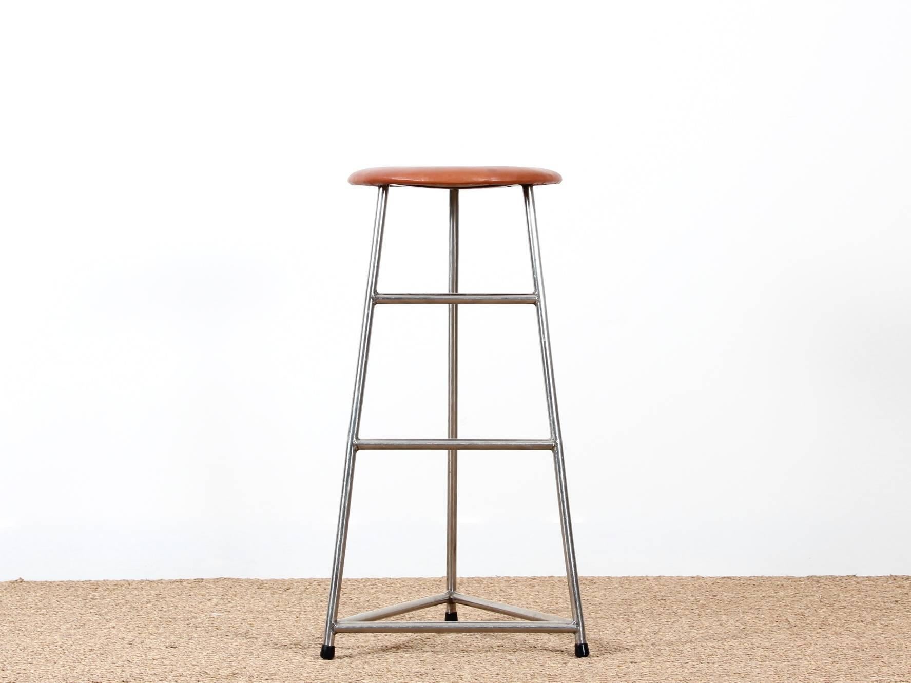 Scandinavian bar stool. Structure welded steel, three feet. Two levels of footrests. (Ideal for guitarists.) seat with foam and covered with a patinated natural leather. Designer unidentified. Was matched with a series of Arne Jacobsen stools.