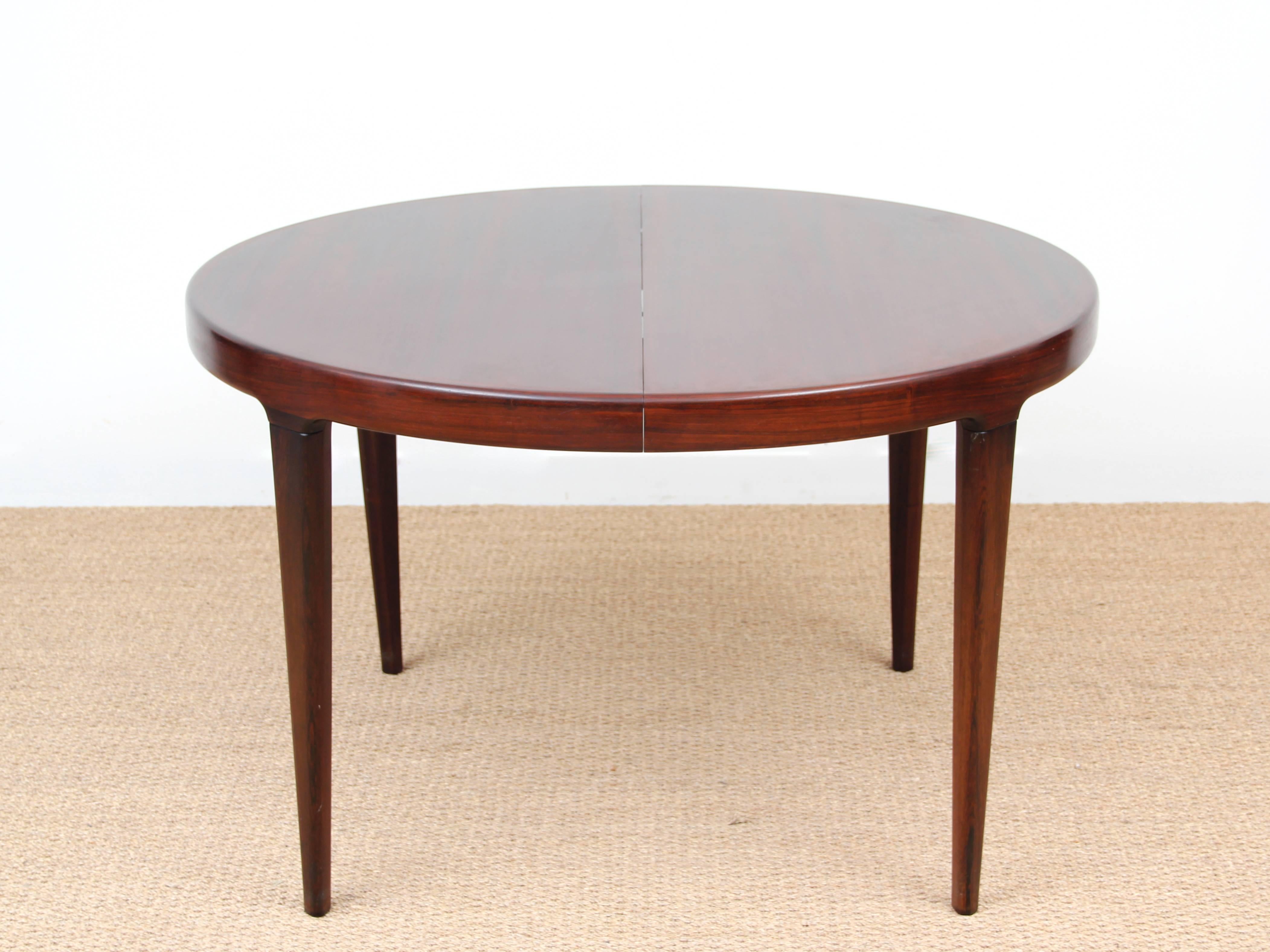 Scandinavian round dining table in rosewood for four to six people. One extension in white melamine. State original exceptional. Some small dents on the board.