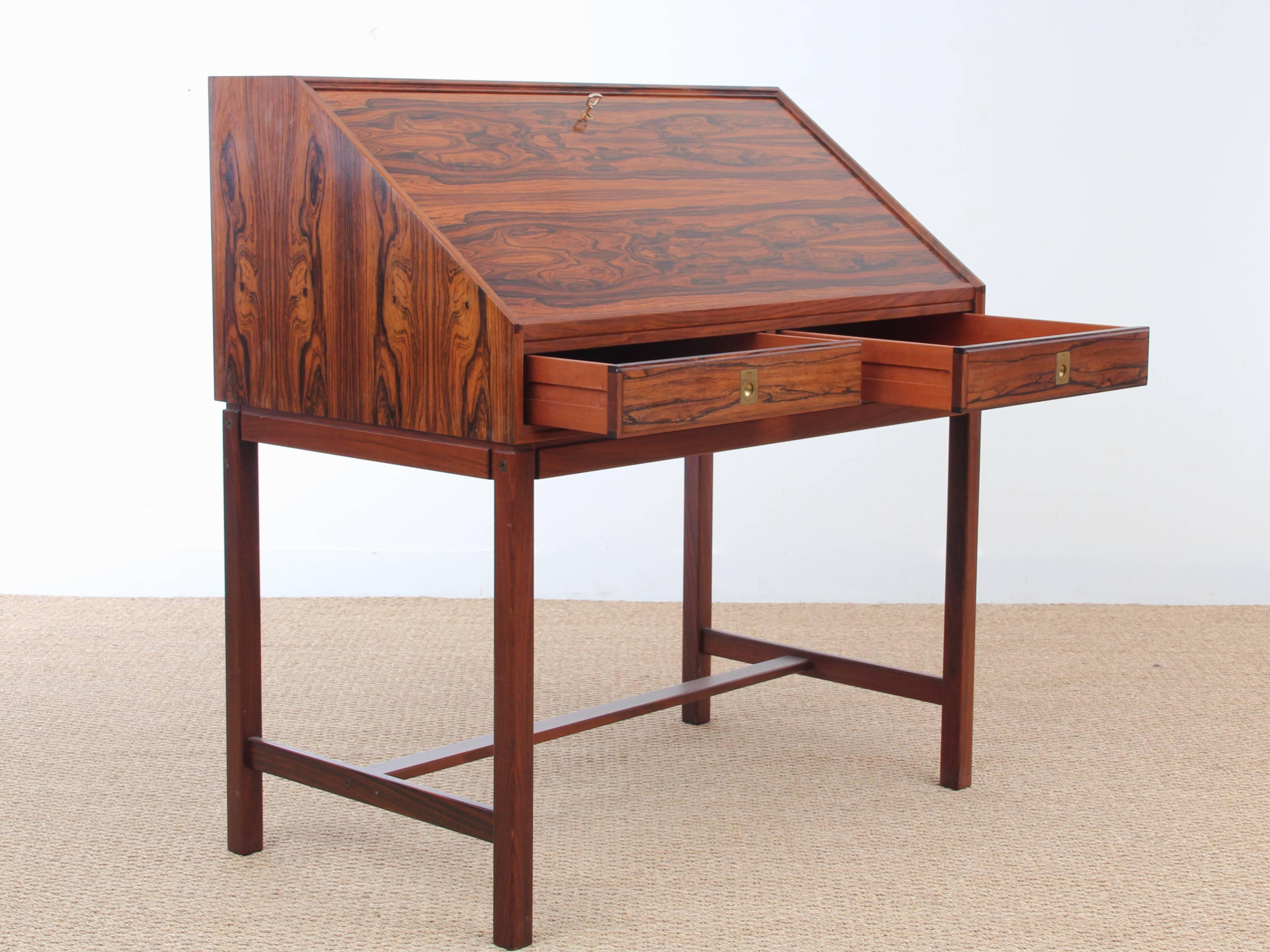 Mid-Century Modern Scandinavian writing desk of rosewood, front with two drawers and folding top, behind which shelves and drawers. Manufactured by Dyrlund. Exceptional original condition.