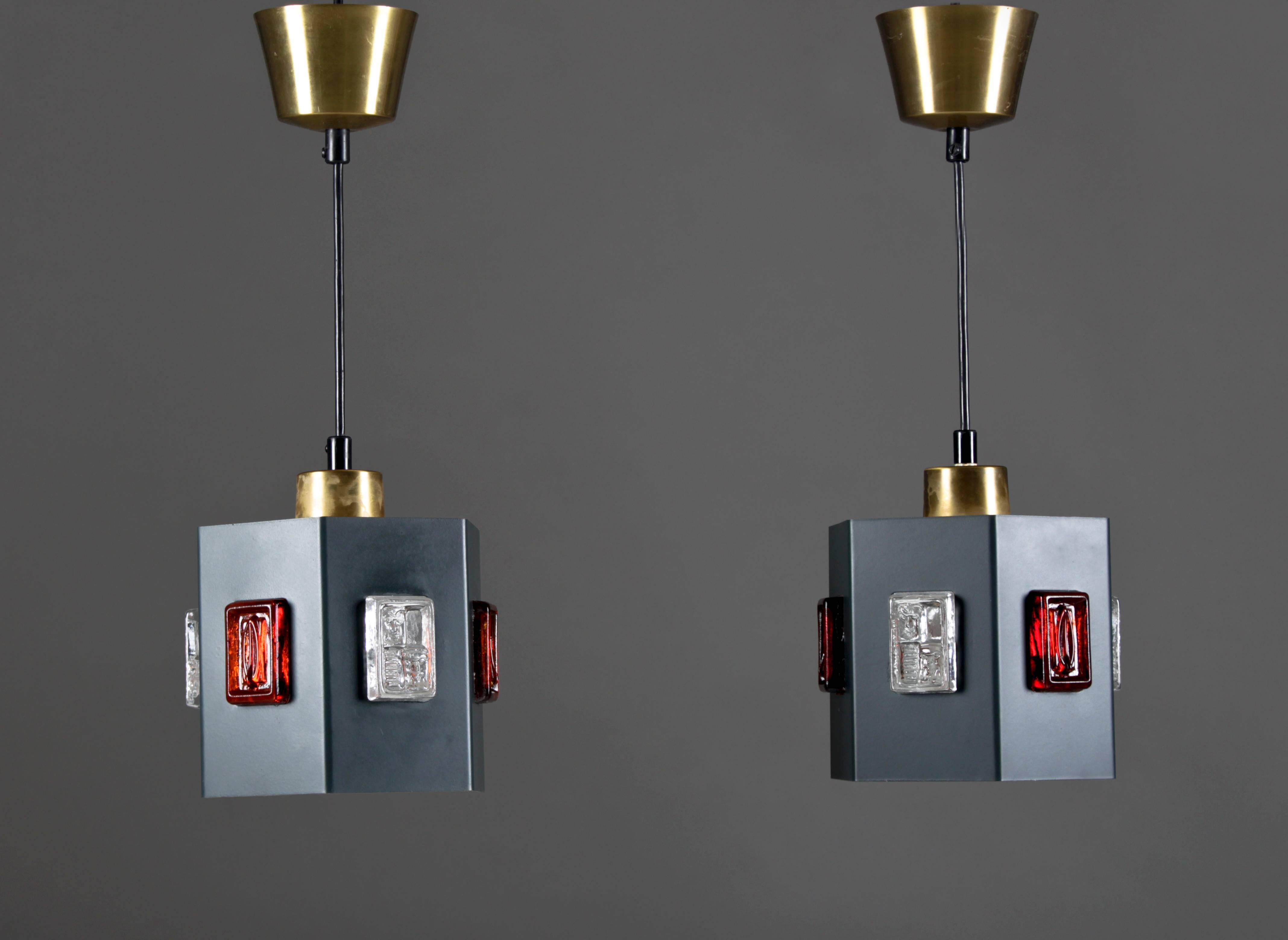 High-quality ceiling lights in brass, lacquered metal and glass. Simple cubist shapes and superb color matching give these lamps something extra. The lamps are made by Einar Bäckström and the glass parts by Erik Höglund. The brass parts have a