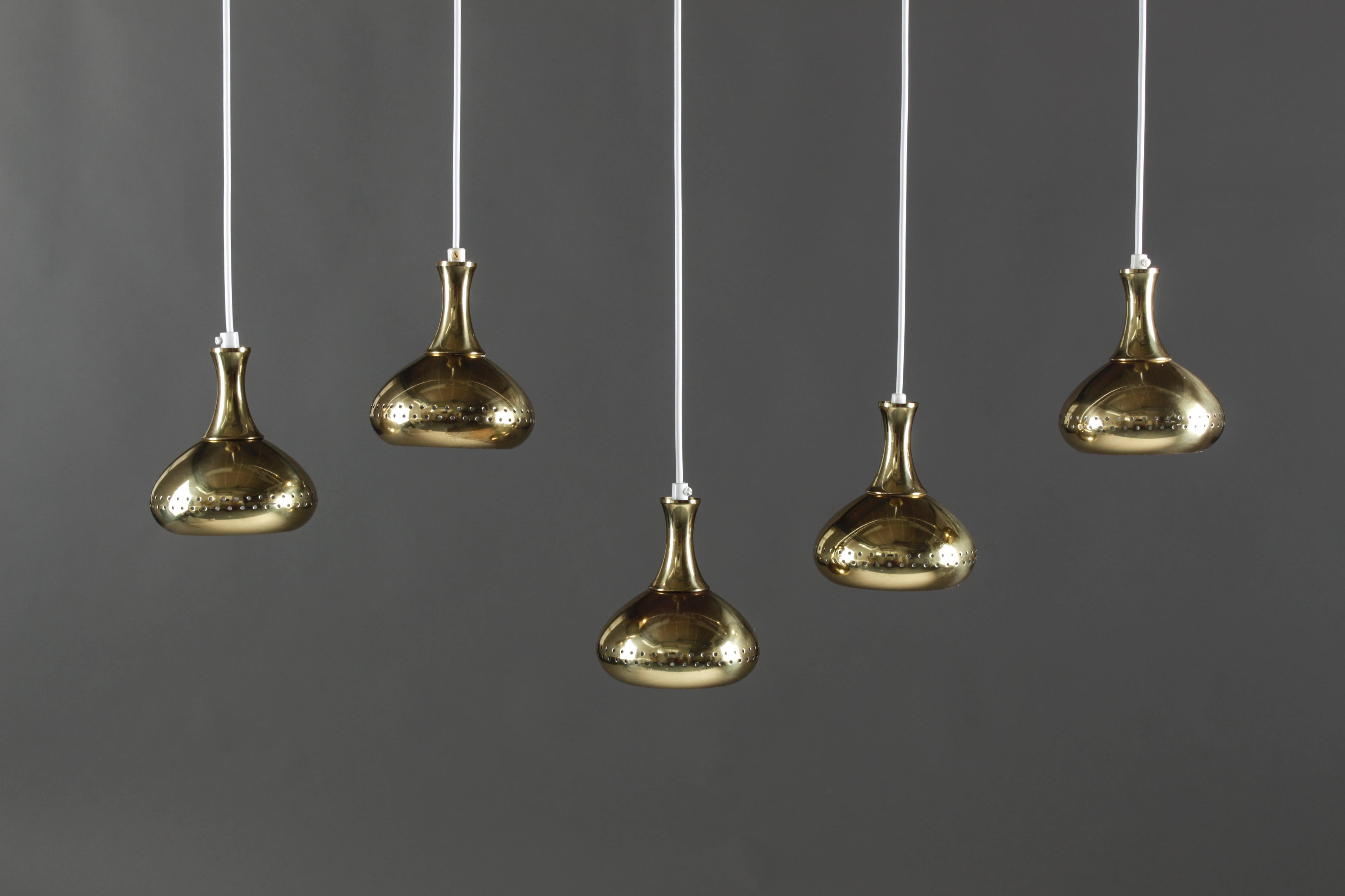 Set of five small pendants in perforated brass designed by Hans-Agne Jakobsson. The lamps come with new wiring and the length can be altered according to your requirements.
