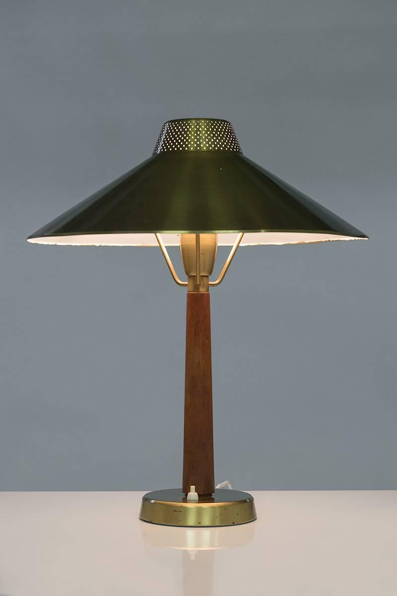 Table lamp model 716 by Hans Bergström for Ateljé Lyktan. The shade is made of brushed brass which is perforated on the top, and the base is made of teak. As with all Bergström lamps, the quality is great.
The shade is slightly askew and shows minor