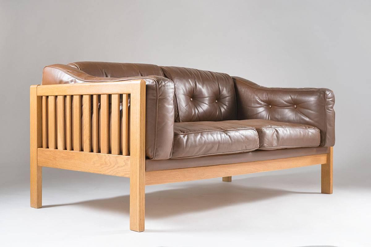 Top-quality sofa designed by Ingvar Stockum for Futura Möbler in 1965. This sofa was only in production for two years because production costs were too high. The sofa is made of solid oak, and leather cushions filled with polyethylene.
This sofa is